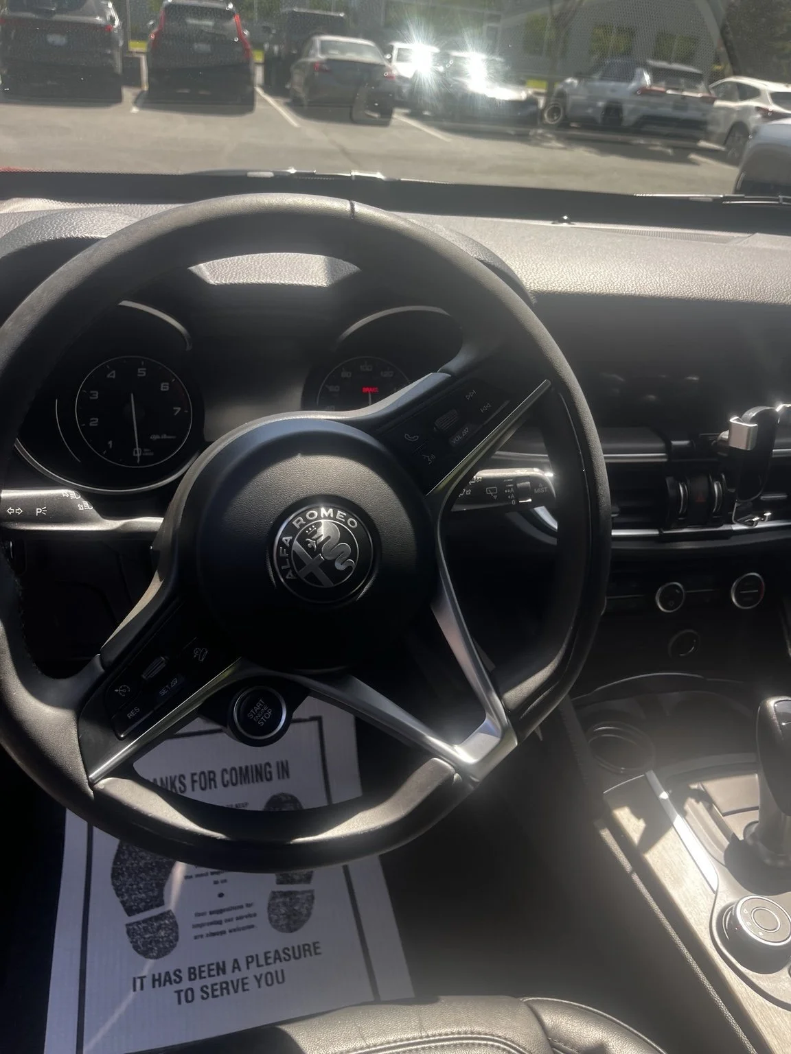 Alfa Romeo driver area after professional interior detailing in Renton WA featuring a clean steering wheel dashboard center console and interior surfaces