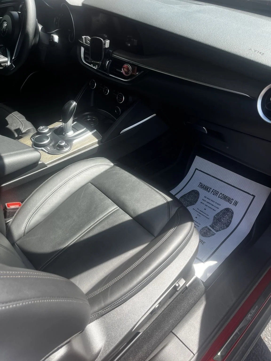Alfa Romeo front cabin after professional interior detailing in Renton WA featuring clean leather seats center console dashboard and passenger area