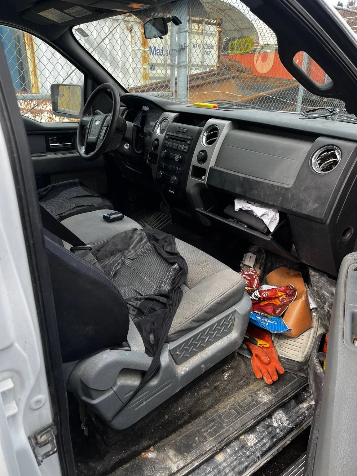 Dirty work truck interior before restorative interior cleaning - Ford F150 with stains, debris, and heavy dirt buildup prior to deep interior detailing service.