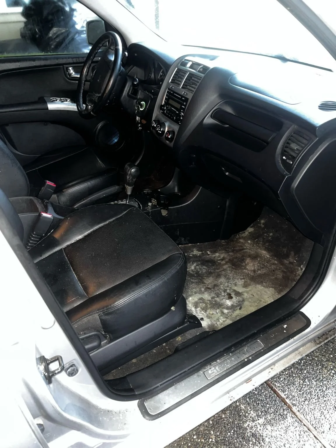 Before restorative interior cleaning on Suzuki Grand Vitara showing heavy floor stains, dirt buildup, and neglected interior before deep detailing service.