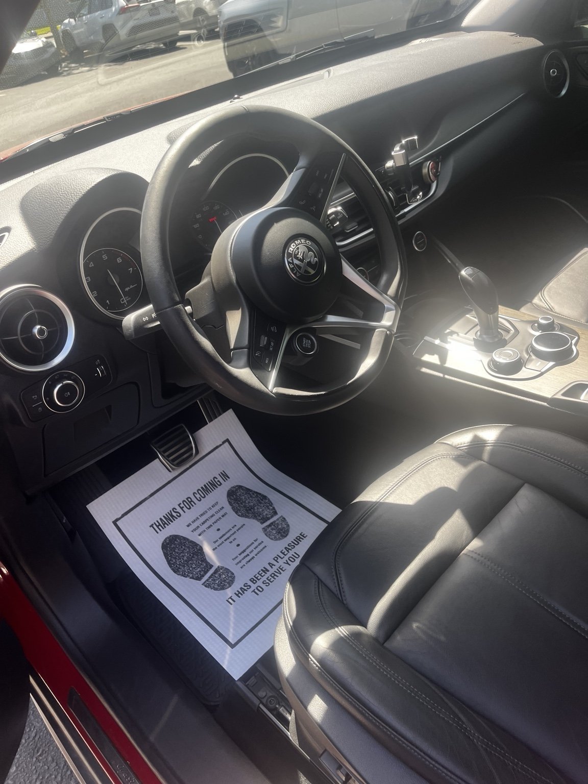 Alfa Romeo interior detailing service in Renton WA featuring cleaned leather seats center console dashboard and driver area with a refreshed finish