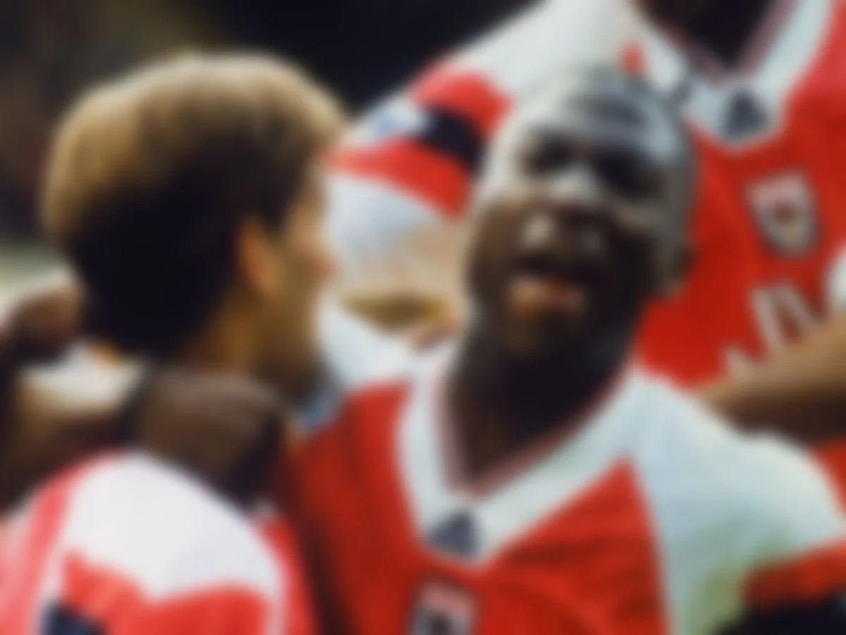 Blurry image of soccer players in red and white jerseys celebrating