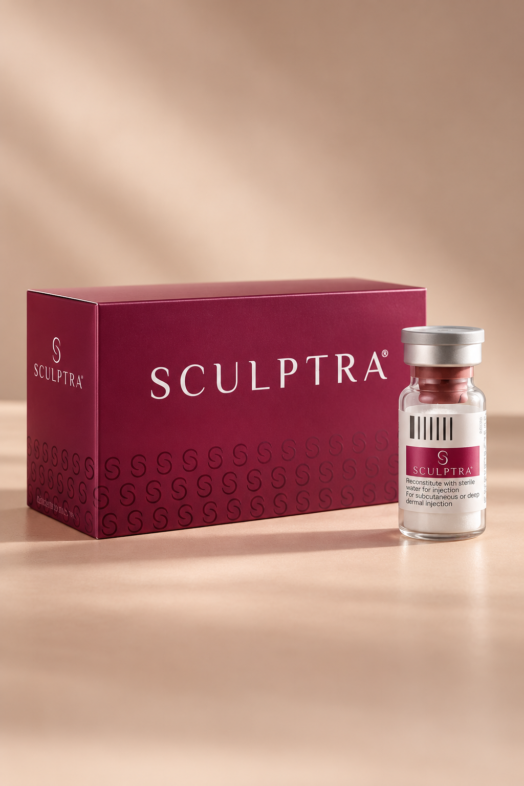 A box and a vial of Sculptra, a cosmetic treatment product, placed on a light-colored surface with a blurred beige background.