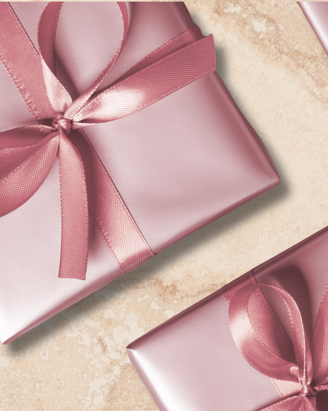 Pink gift boxes wrapped with satin ribbon bows on a beige textured surface.