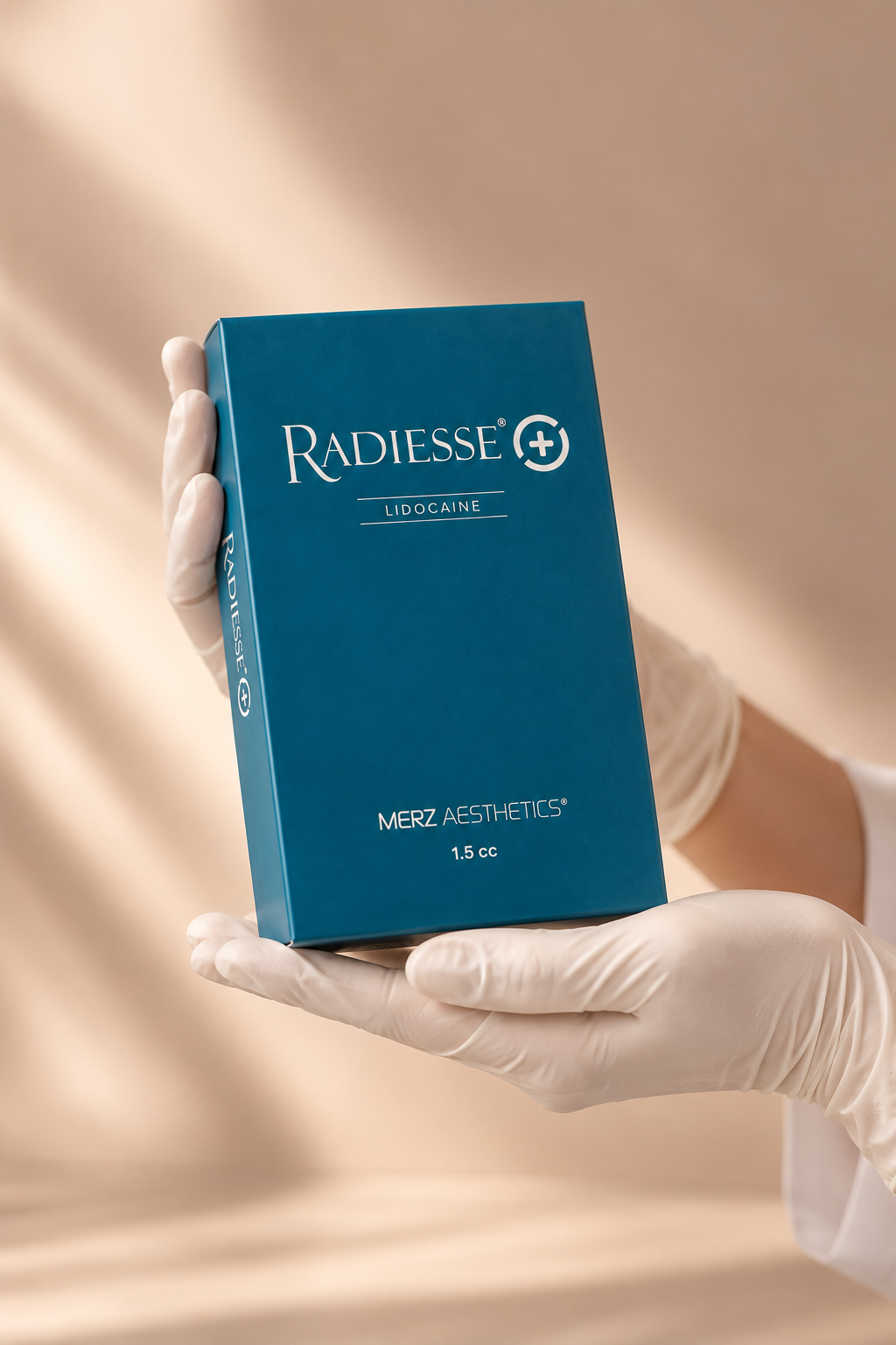 Person wearing gloves holding a blue box of Radiesse Lidocaine, a cosmetic dermal filler, with the brand name, dosage, and volume labeled on the box.