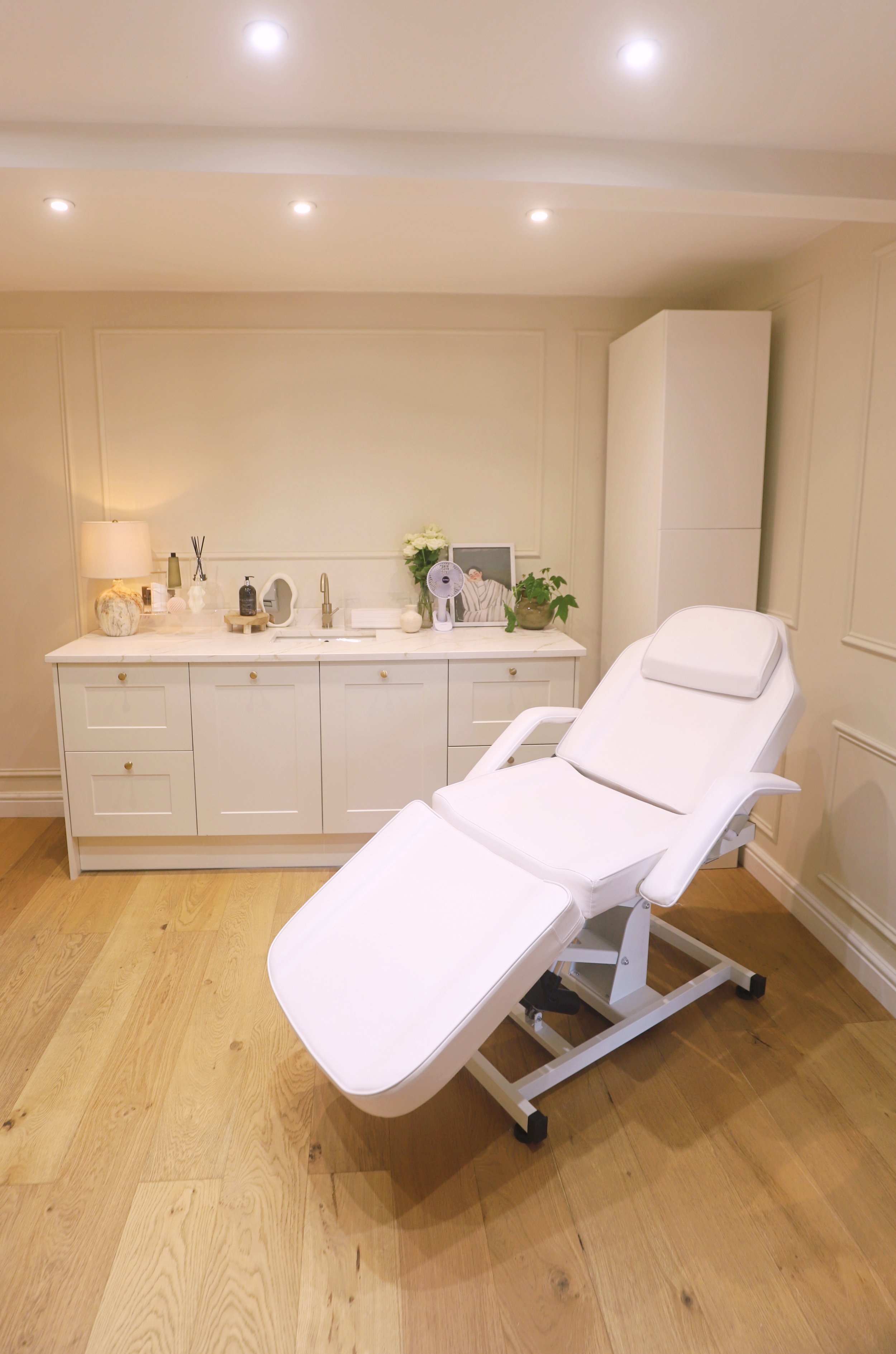 Aesthetic treatment room with reclining medical chair and skincare products in Hale, Cheshire