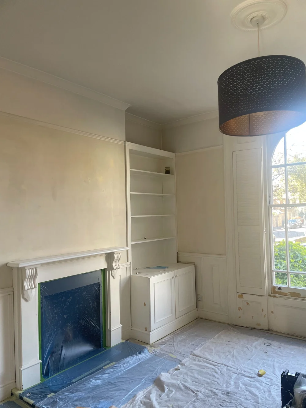 Living room before painting, bare plaster and dust sheets