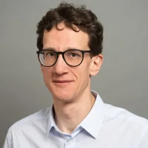 a man with curly hair and glasses
