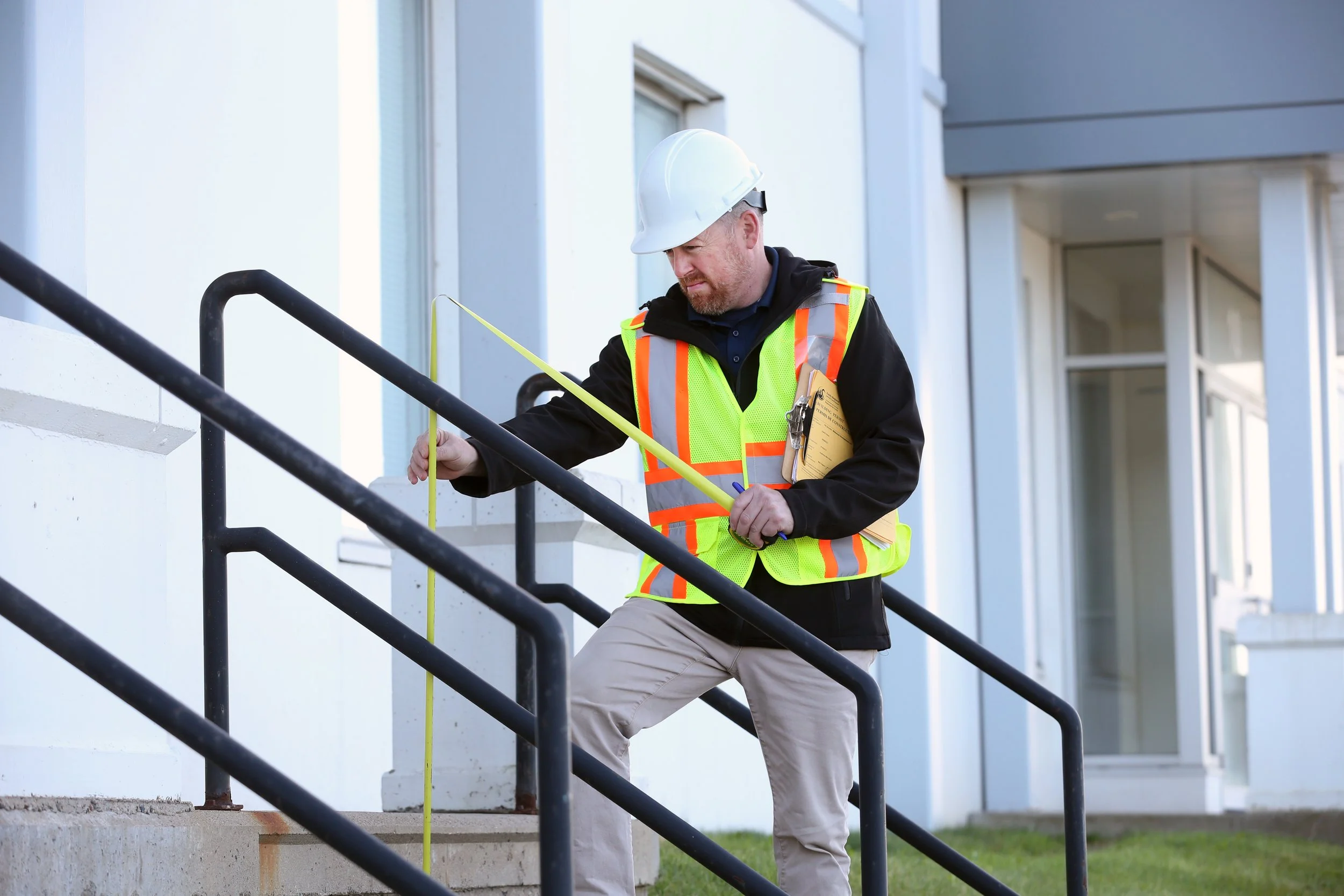 Construction worker measuring railing