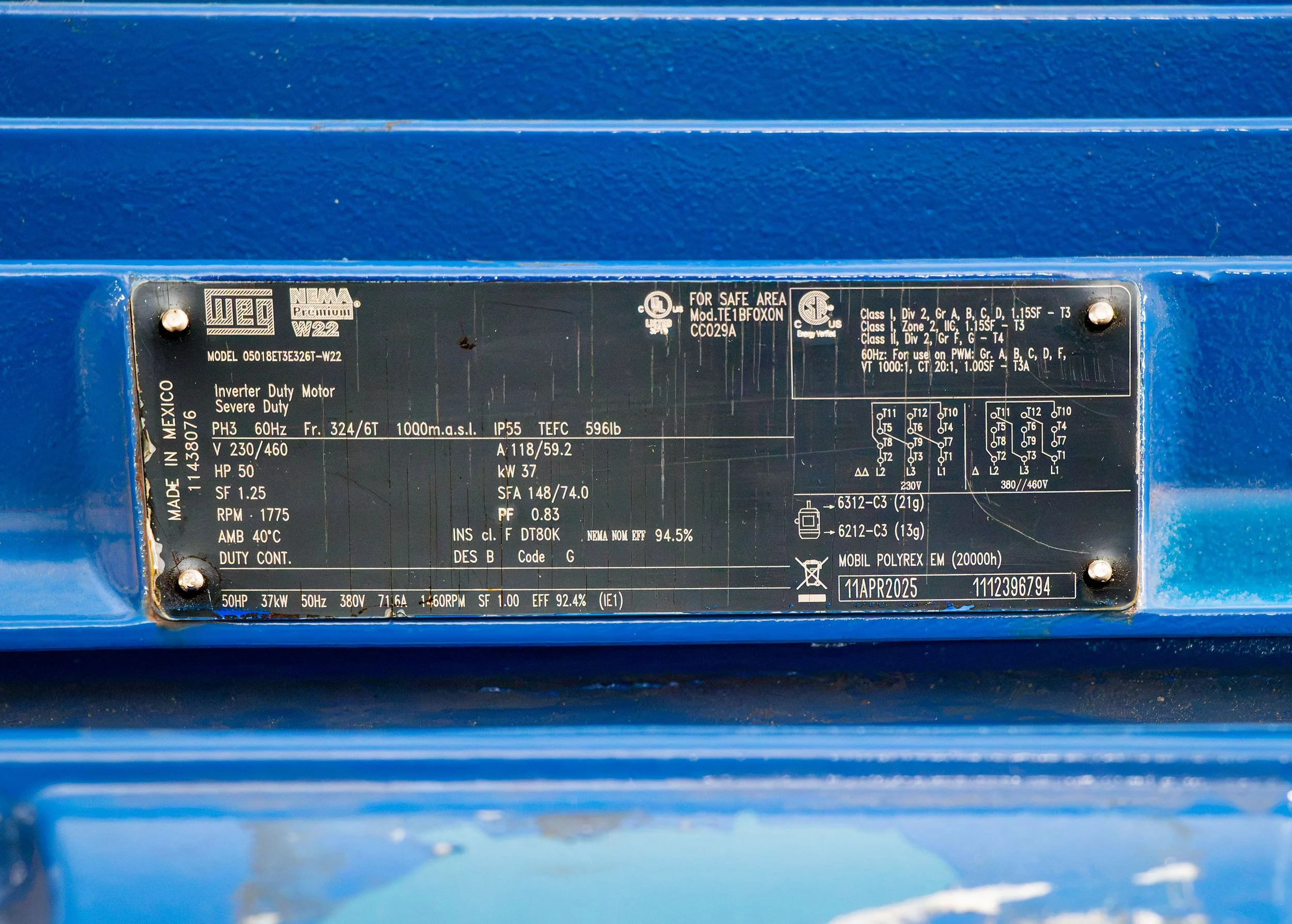 Close-up of a WEG 50-horsepower electric motor specification plate on a blue Thompson Pump.
