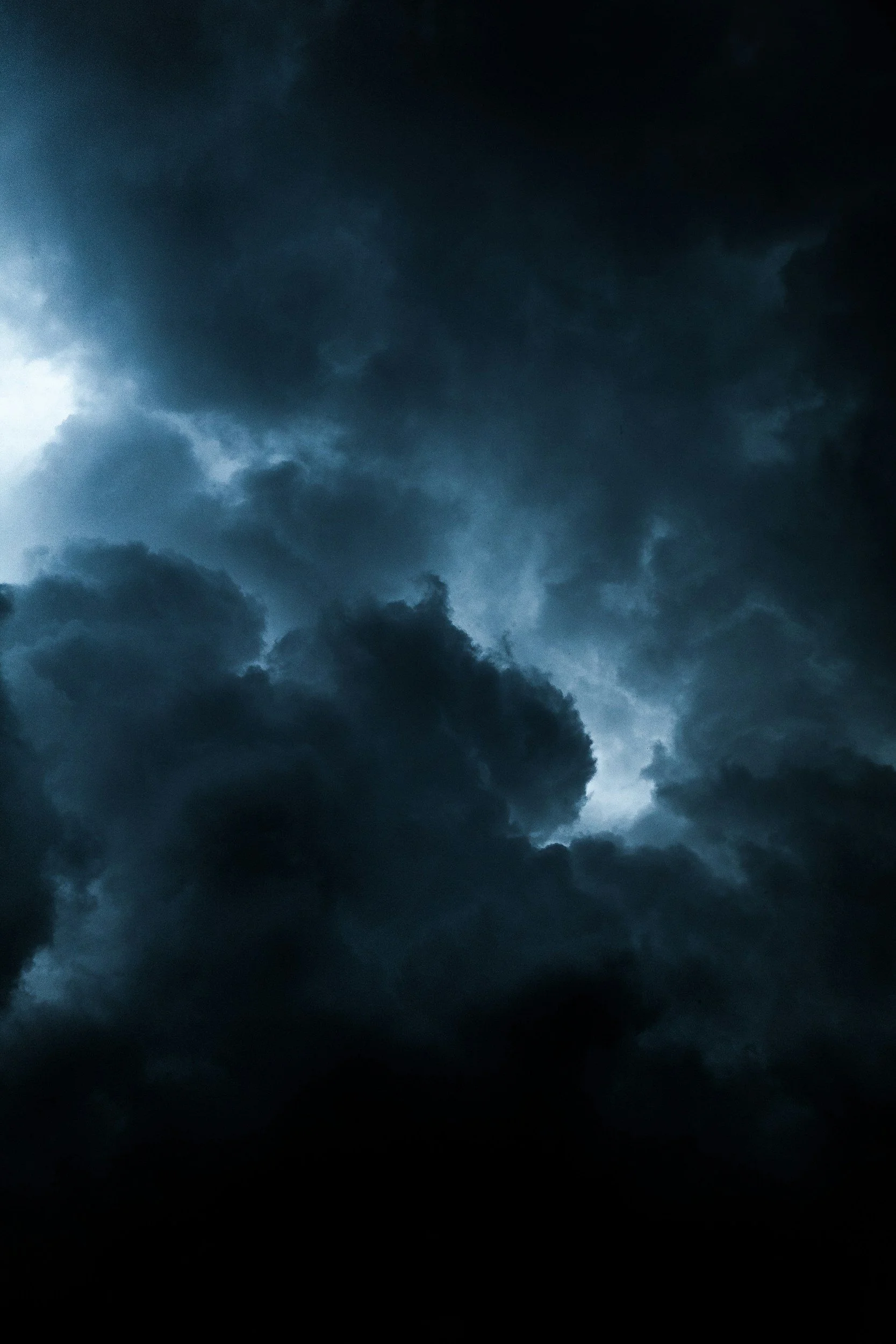 Dark storm clouds in the sky with a slit of light breaking through.