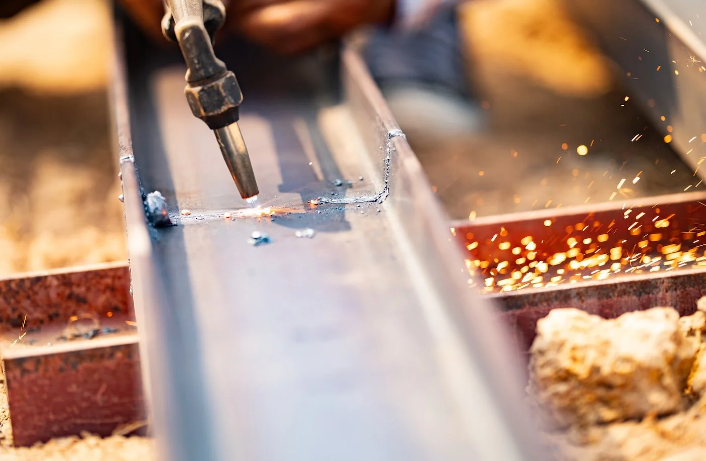 Welding metal rail with sparks and bright light from welding torch