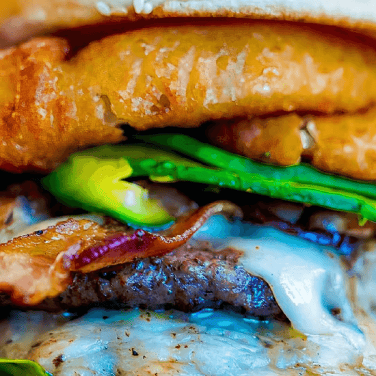 Close-up of a burger with a fried chicken fillet, green lettuce, bacon, cheese, and a fried egg.
