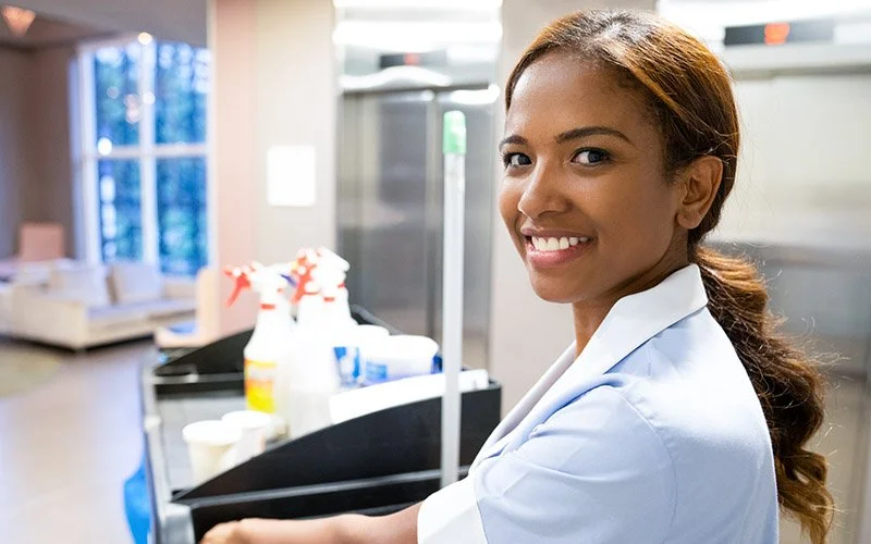 Environmental services person with a cleaning cart