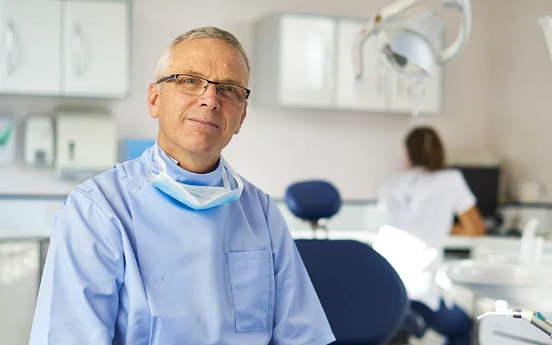 Portrait of a senior level dentist in a patient room