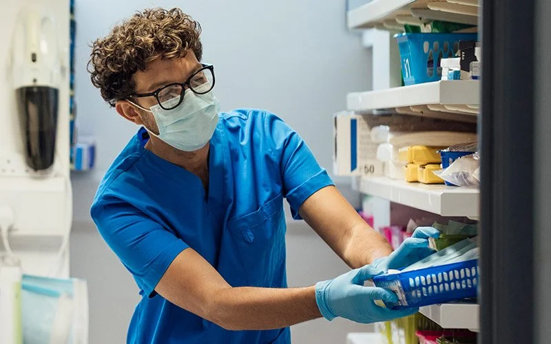 Nurse or dental assistant pulling supplies from a supply area.