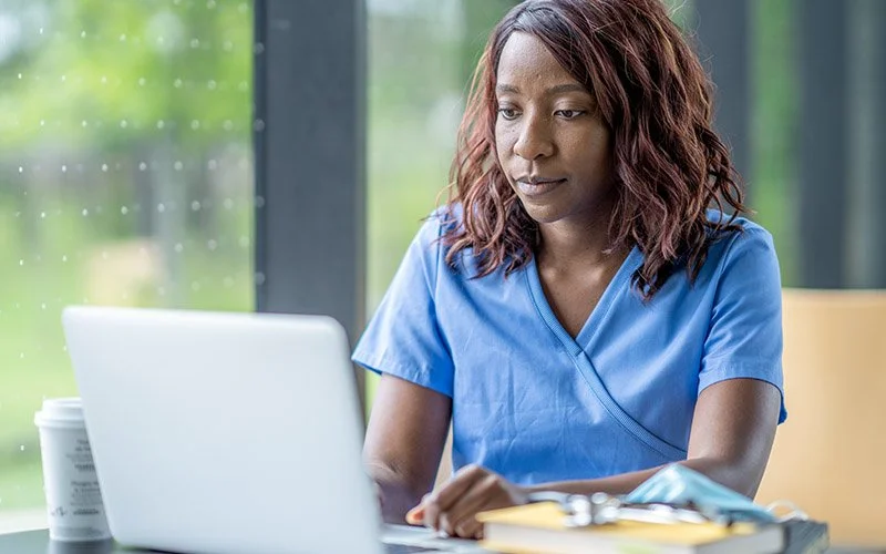 Health care student on her laptop in a library.
