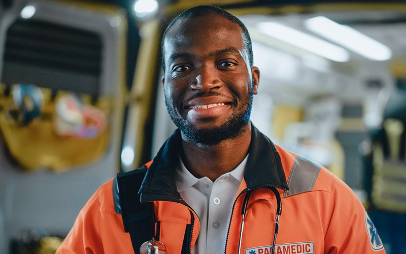 Portrait of a paramedic by the back of an ambulance 