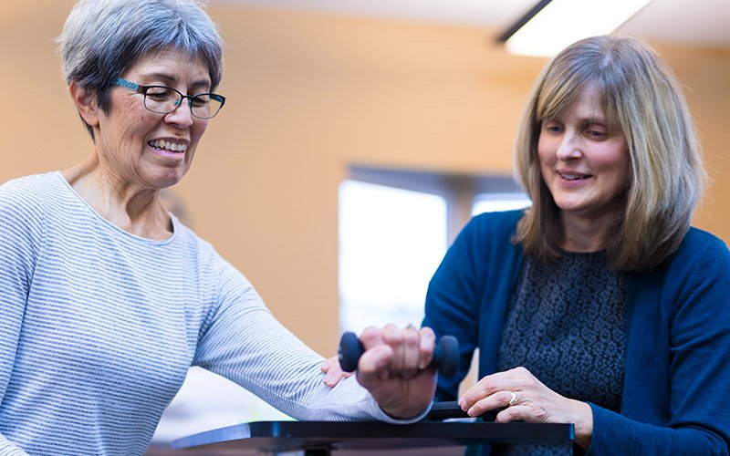 Physical therapist with a patient who is doing wrist exercises 