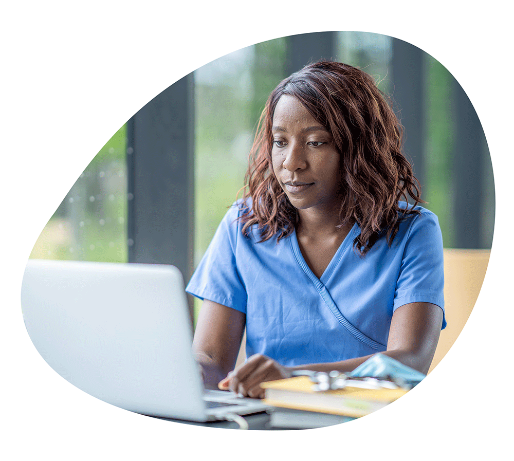 Nursing student working on her laptop in a library.
