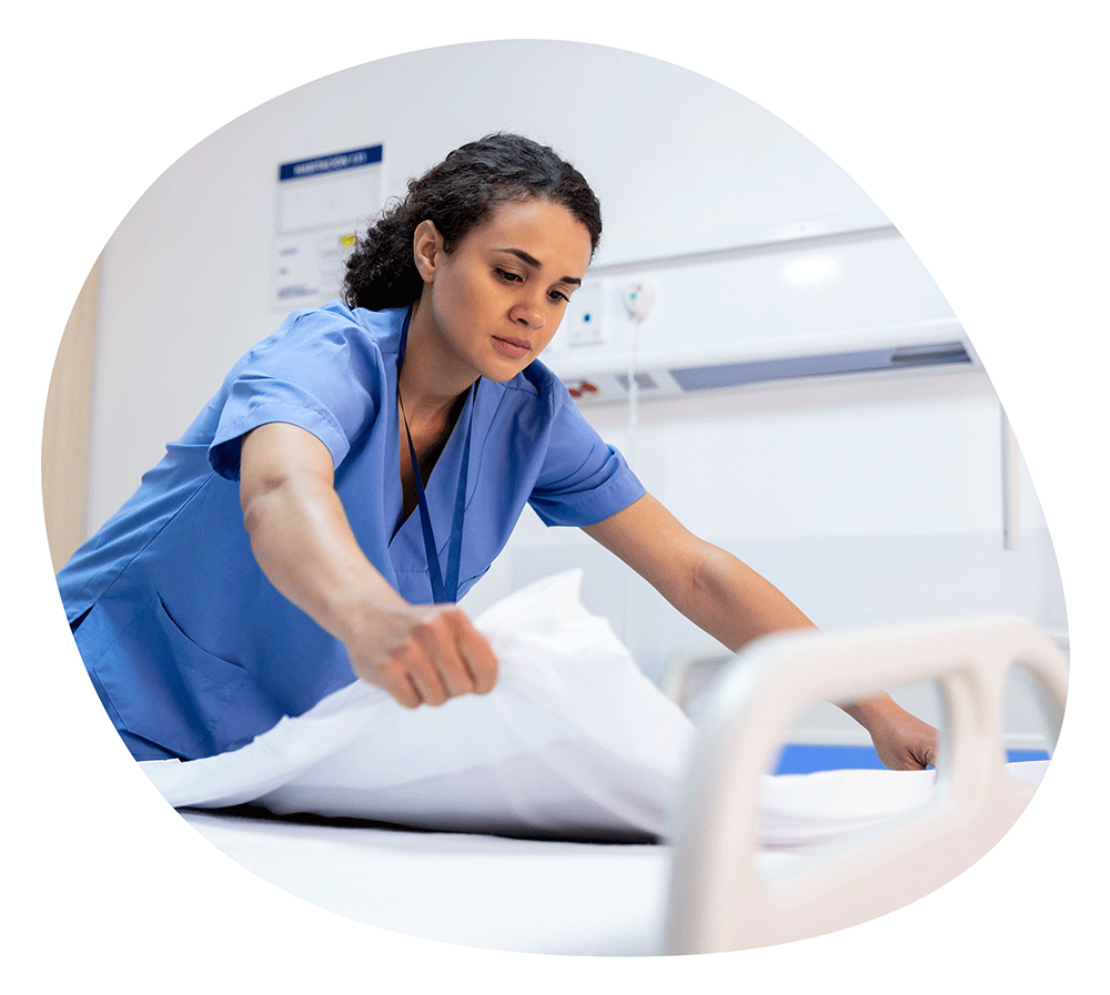 Nurse making up a patient bed