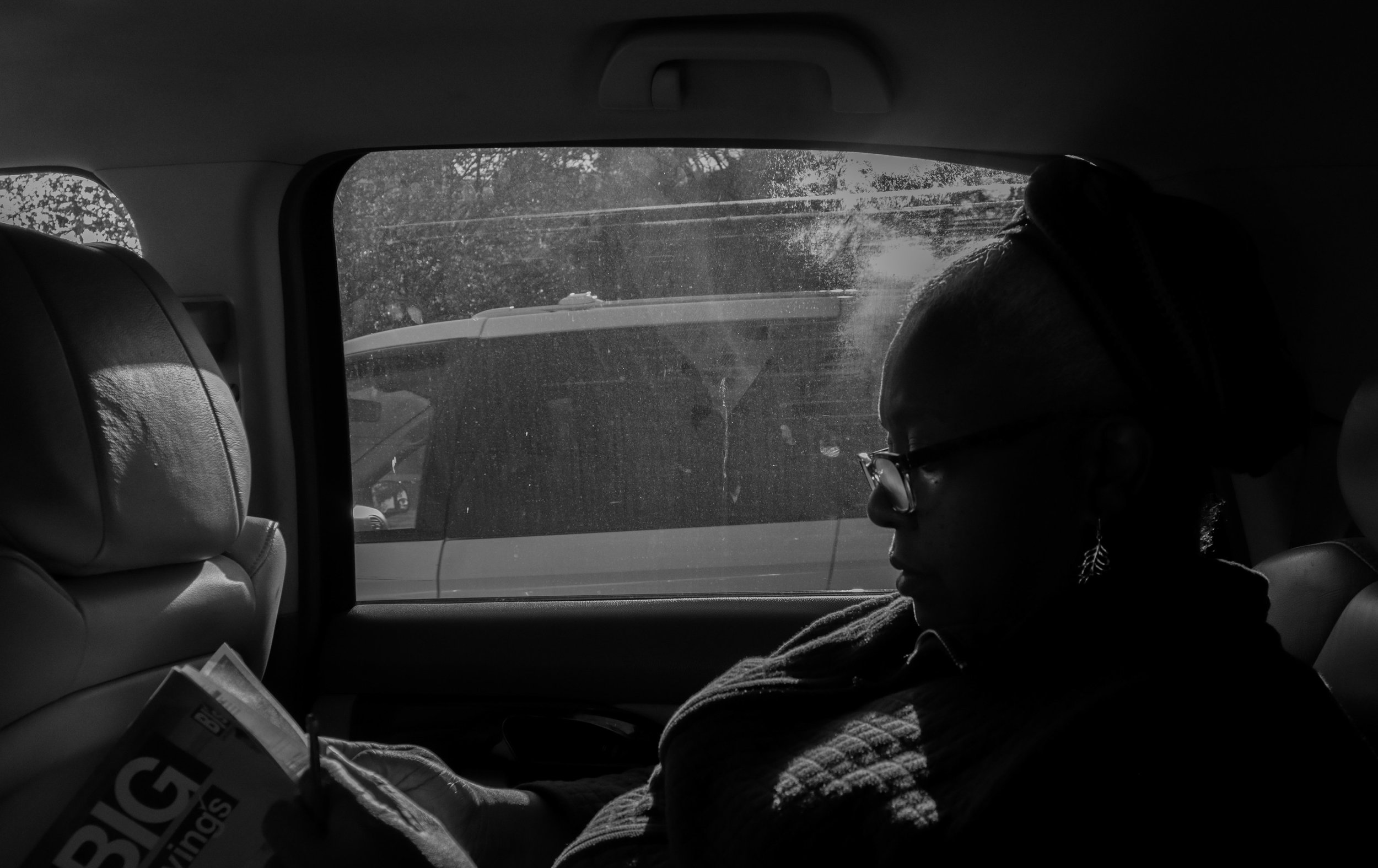 Myrtho sits in the backseat of the car, flipping through a magazine of BJ's coupons. The amount of items to purchase is substantial. Having a collection of coupons eases the burden and helps her save money when she purchases more essentials and peris