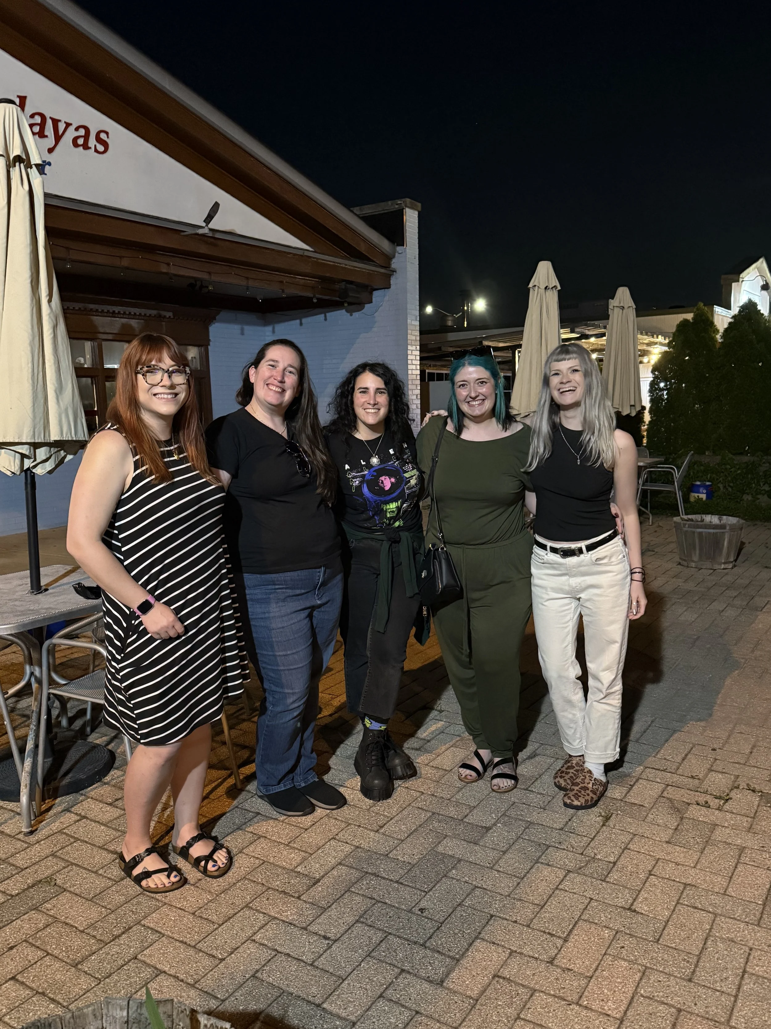 Five people standing together outdoors at night, smiling, with a restaurant in the background from a Chicago meetup.