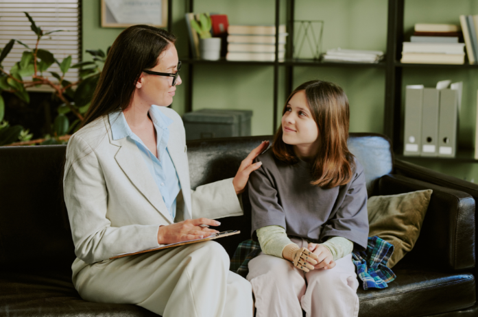 Teen speaking with her teacher, highlighting therapeutic mentoring – Bridge The Gap