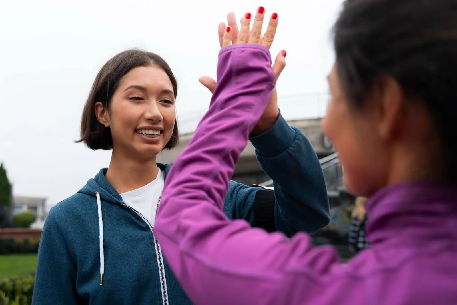 A life coach mentor high-fives a mentee - Bridge The Gap