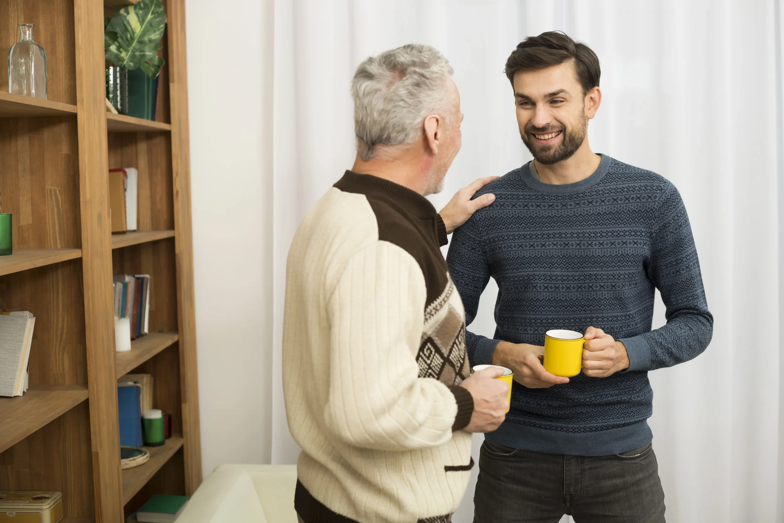 A parent with his young adult son, drinking coffee together - Bridge The Gap Services