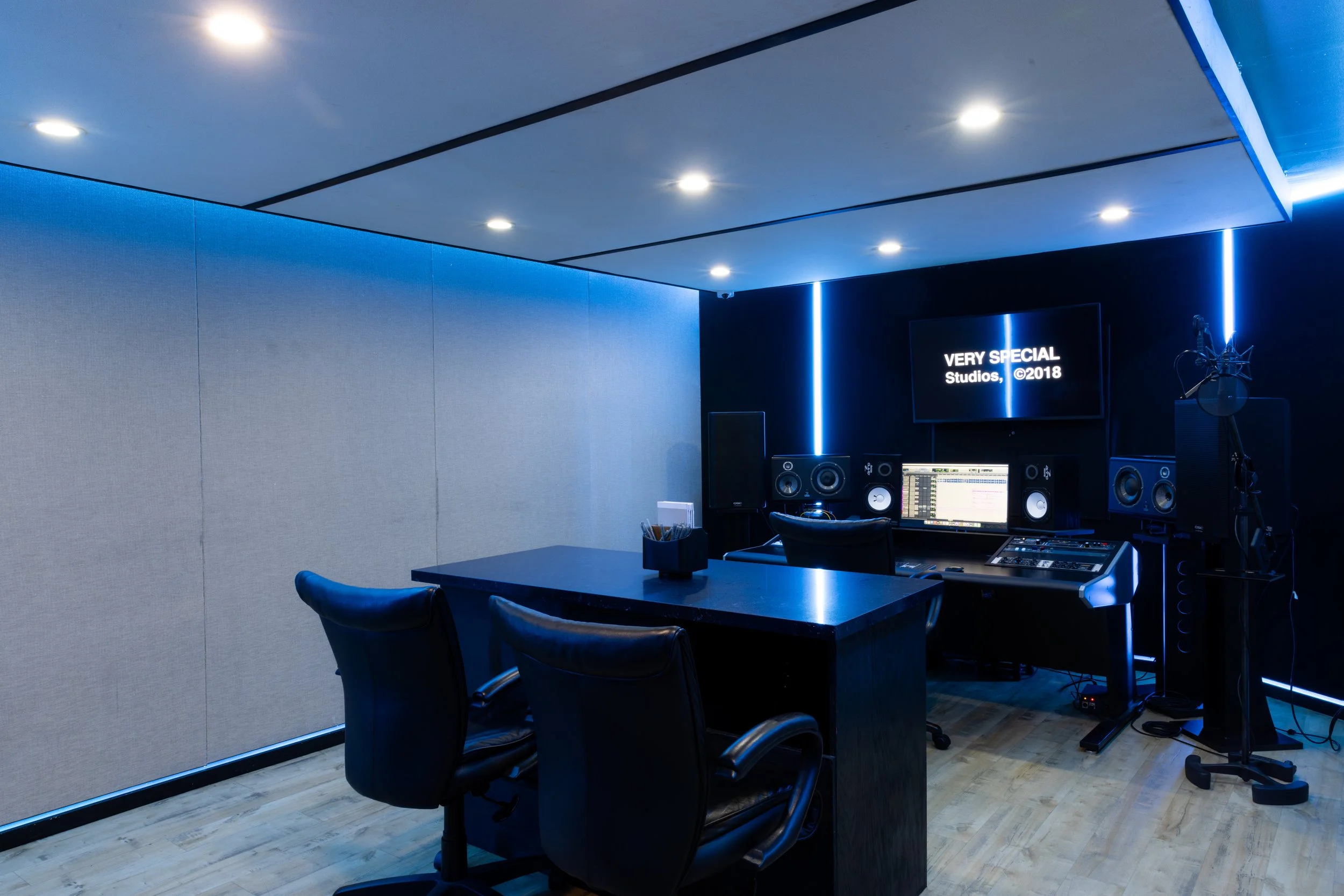 Modern recording studio with mixing desk, speakers, and microphone setup