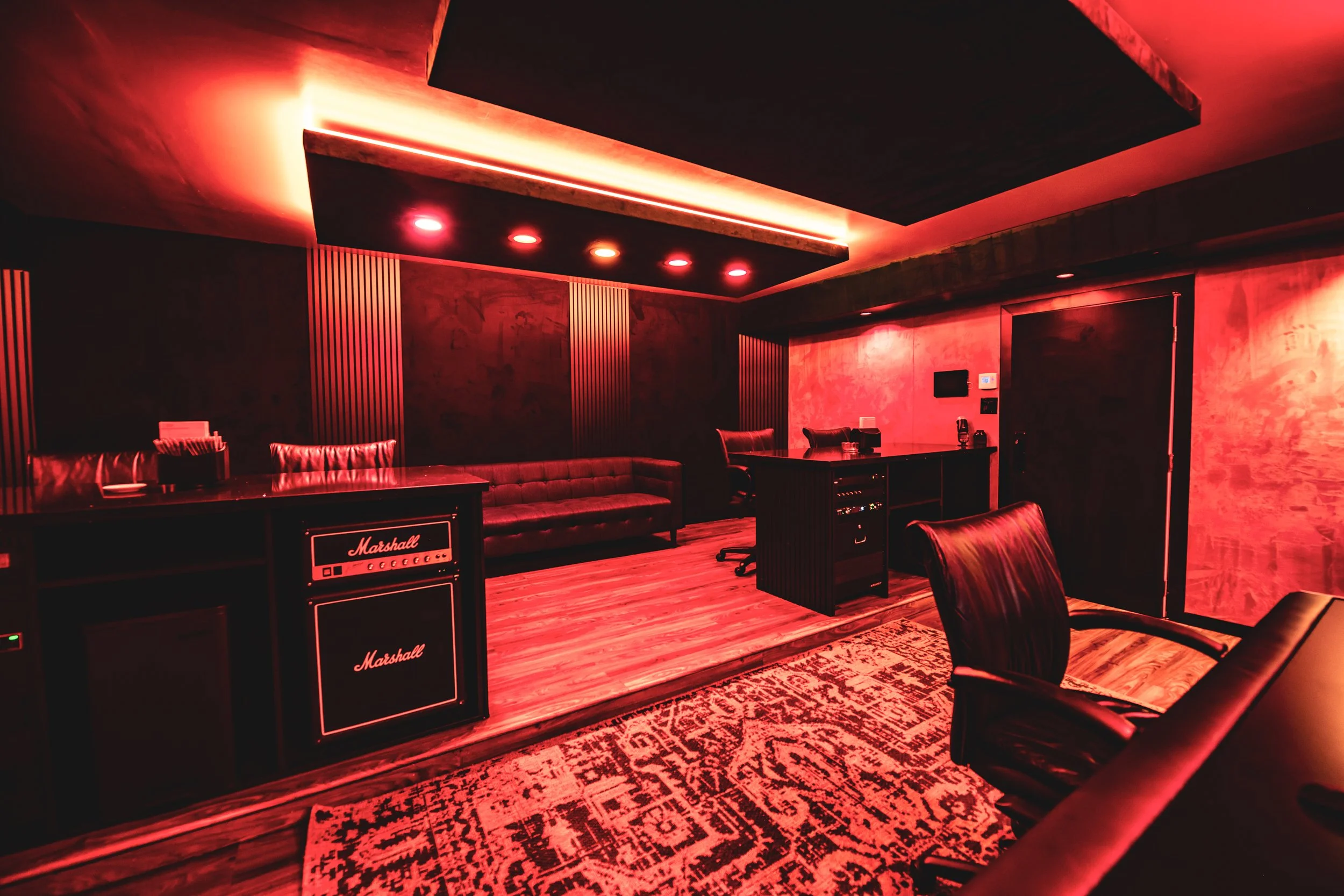 Red-lit music recording studio with Marshall amplifier