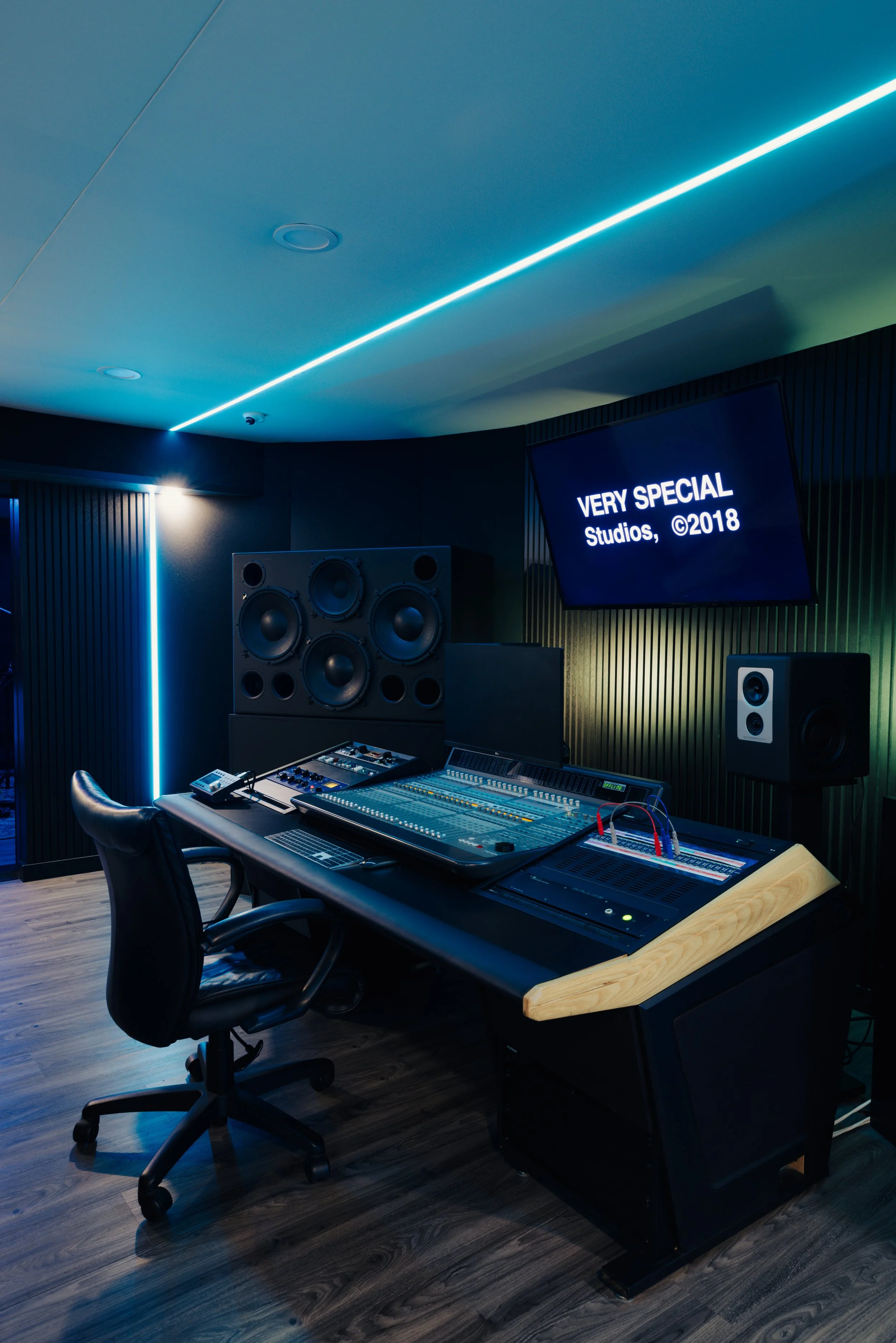 Modern recording studio with mixing desk, speakers, and chair