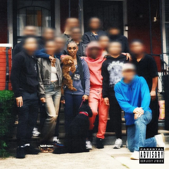 Blurred group photo with individuals and dogs on a porch, explicit content warning in corner.