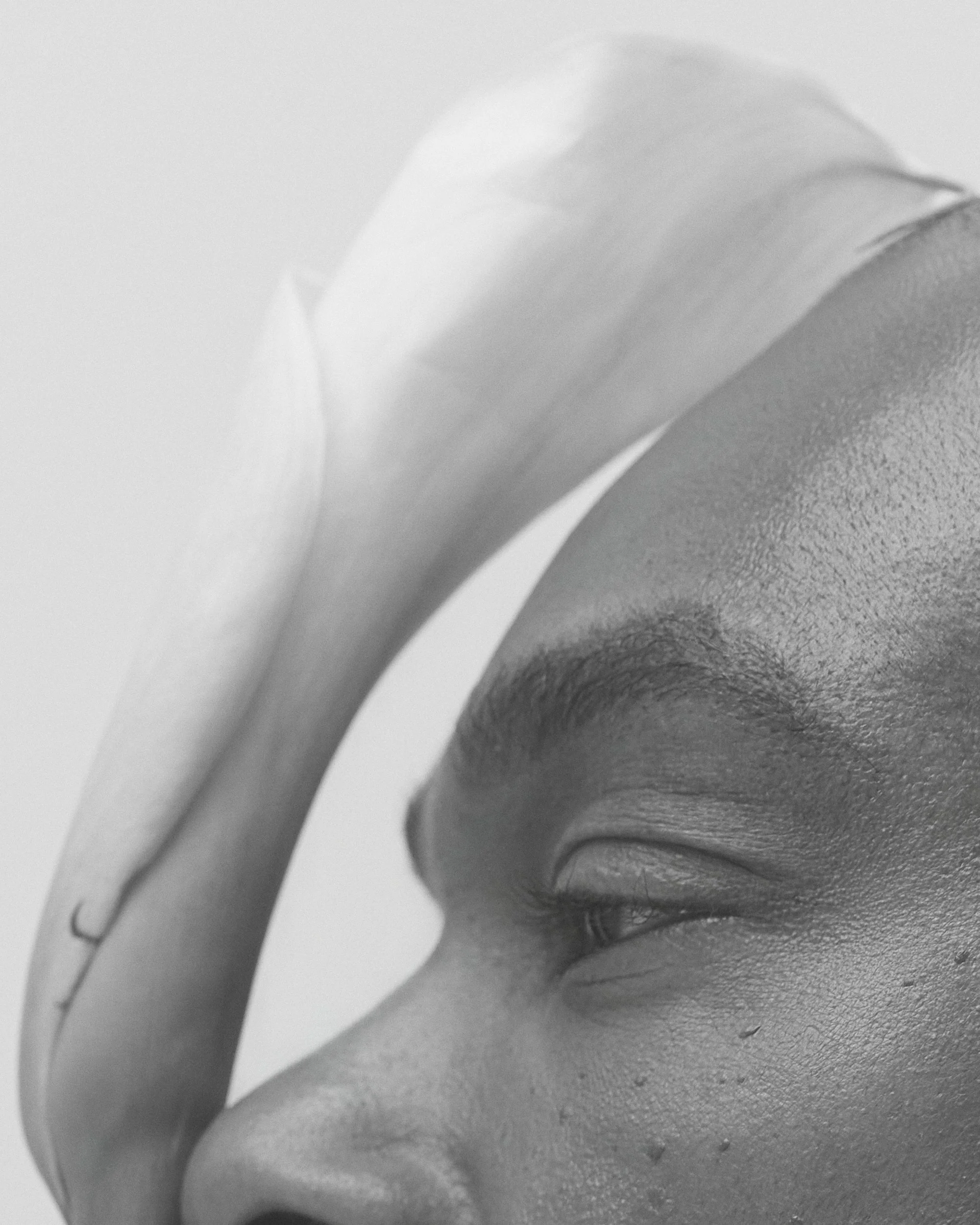 Portrait en noir et blanc d'une femme avec un bandeau blanc sur le front, regardant vers la droite, visage détendu.