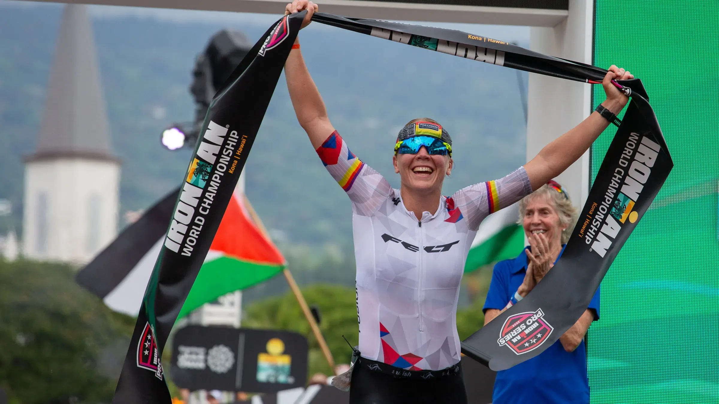 fair skinned woman crossing the finish line at the iron man race in Kona, Hawaii