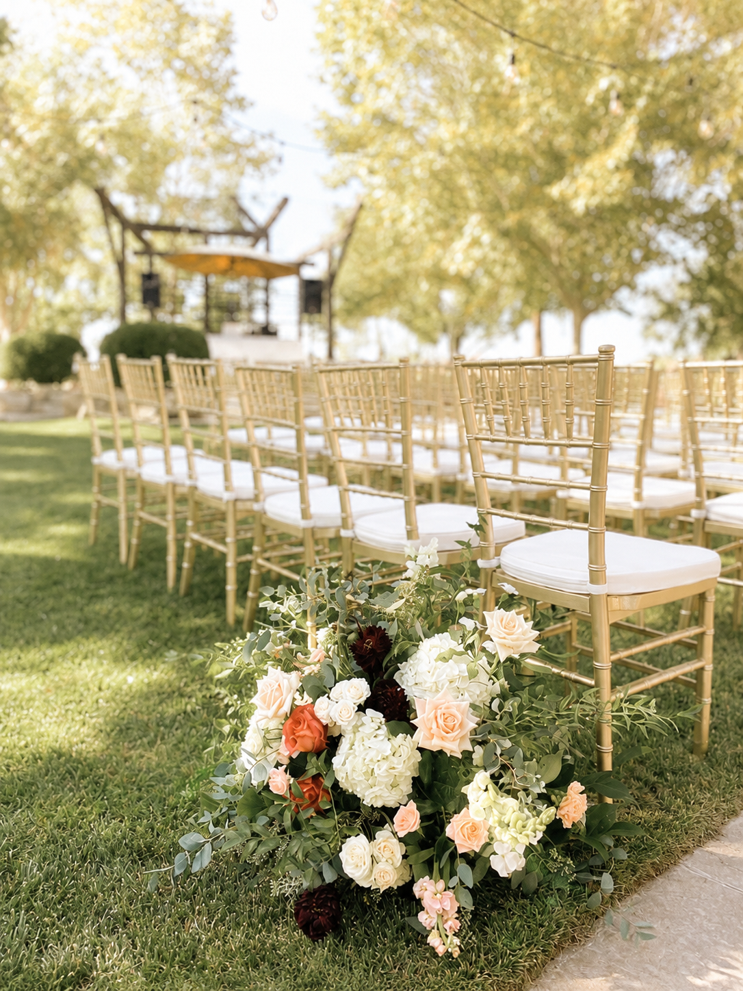 Outdoor wedding setup with gold chairs and floral arrangement on the grass at Four Sisters Ranch wedding venue in Central Coast, California.