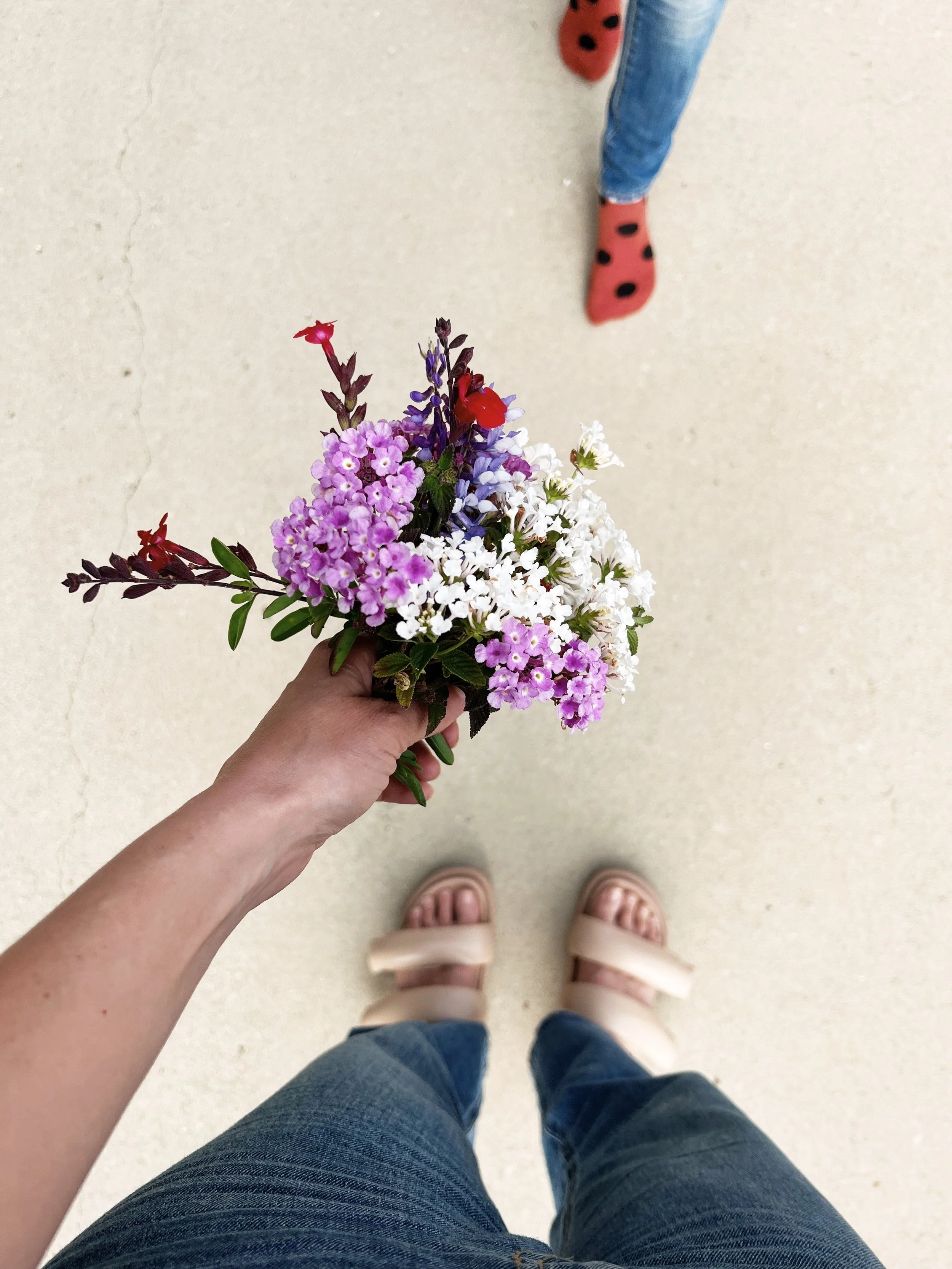 Relational healing that touches motherhood, a mom holds a bouquet out towards her daughter