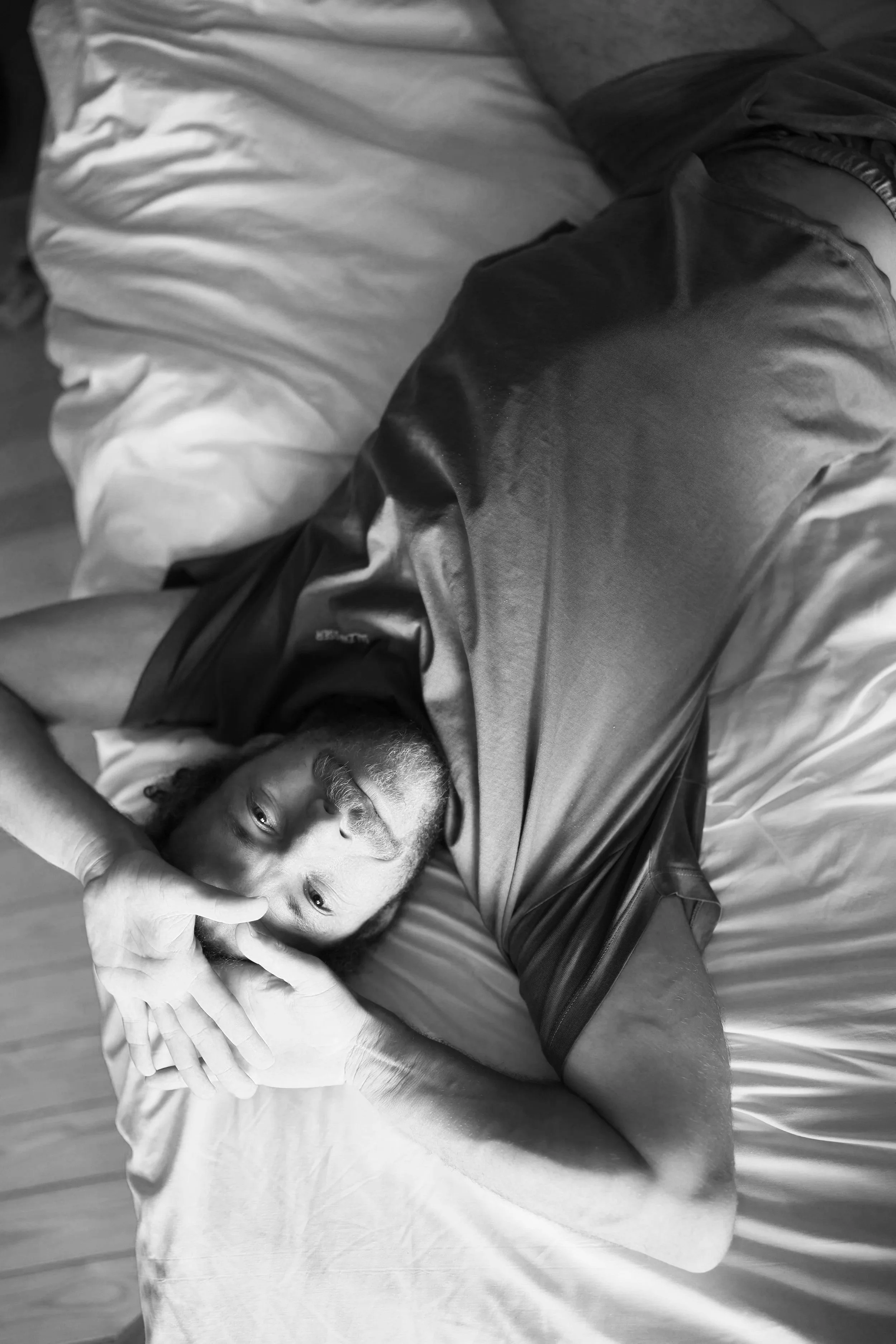 Man lying in bed reflecting stress and its impact on male fertility