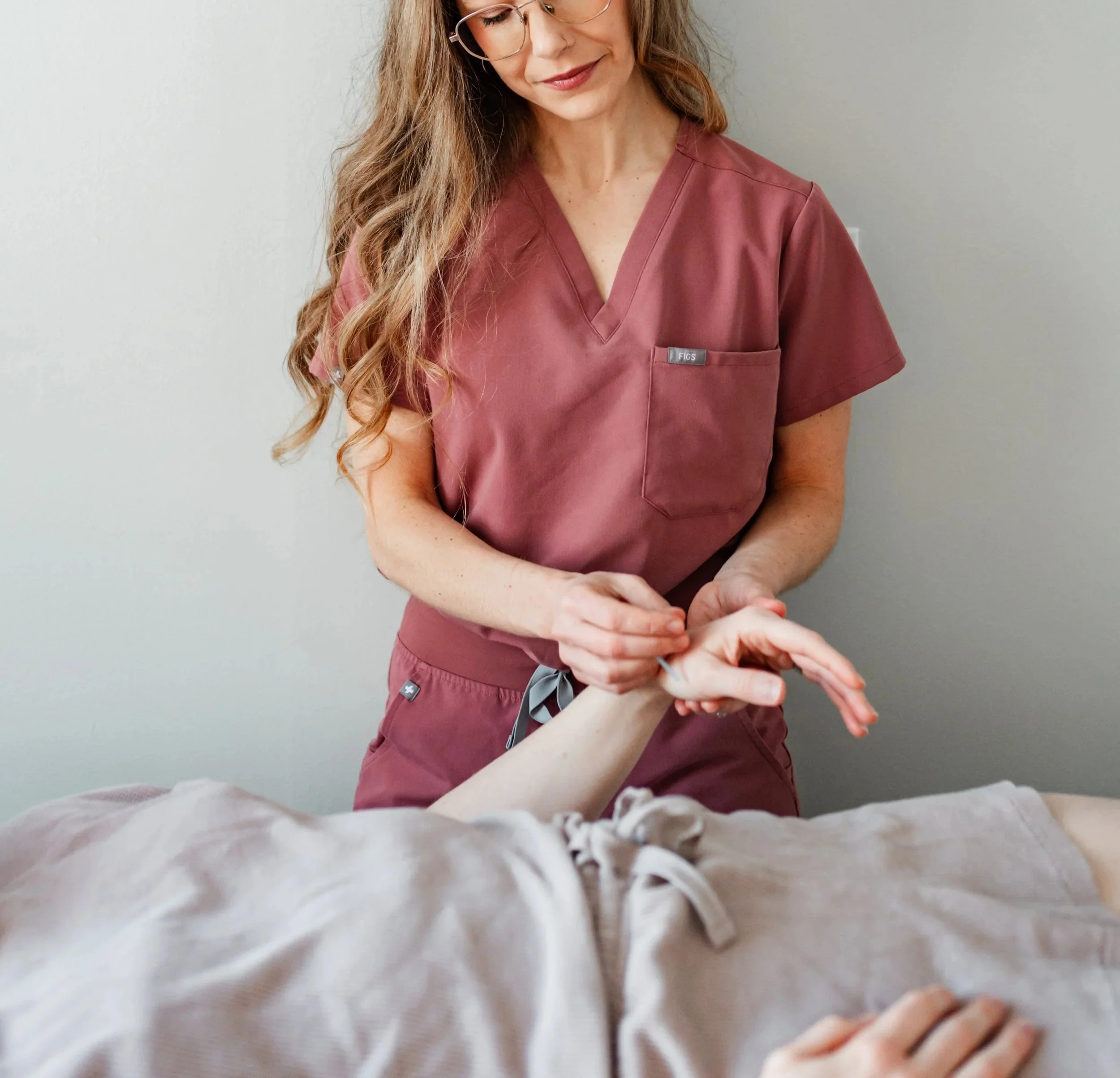 Woman holding hands in supportive care setting at a women’s acupuncture clinic in Groton, Massachusetts.