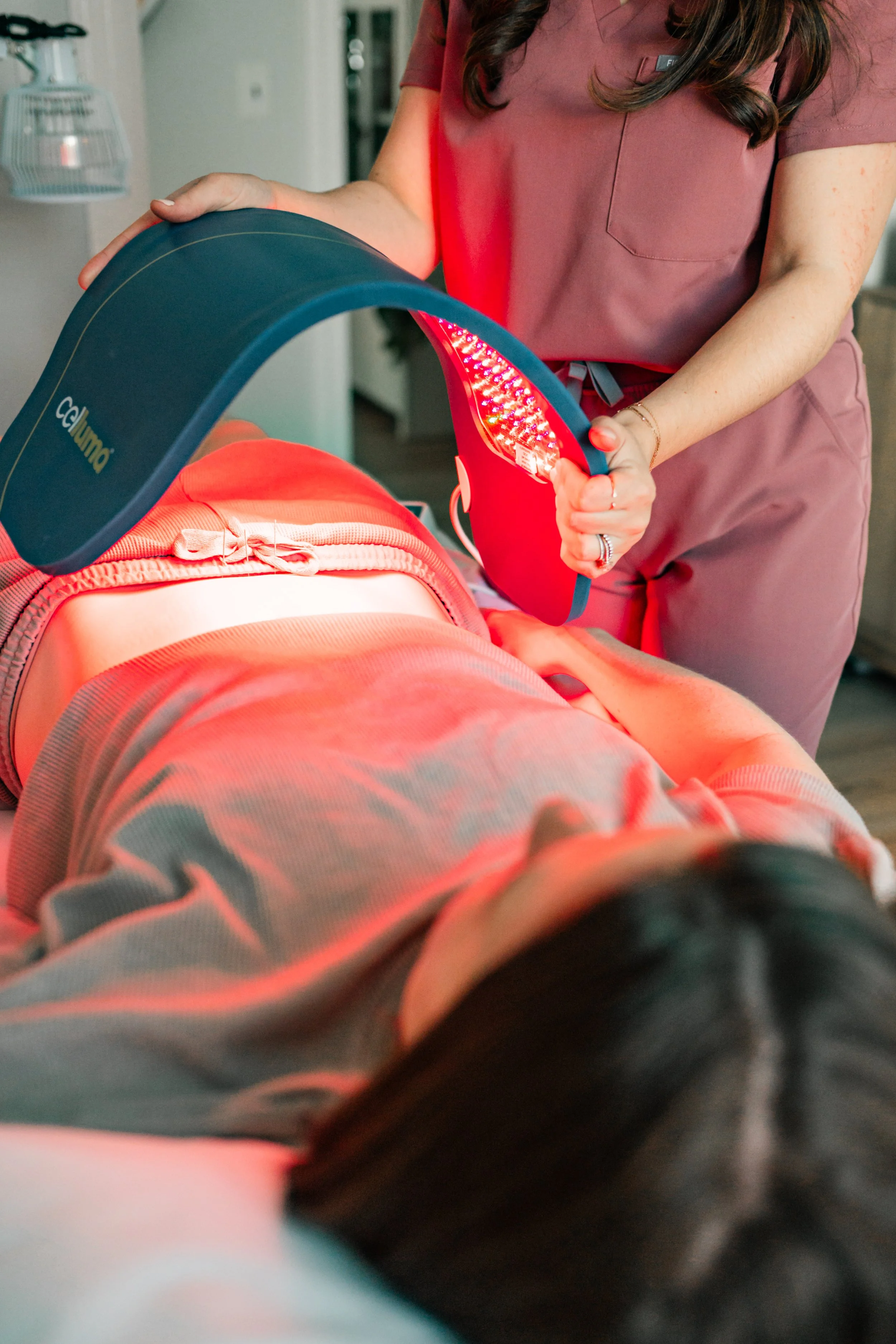 Practitioner applying red light therapy alongside acupuncture at The Violette House in Groton, MA