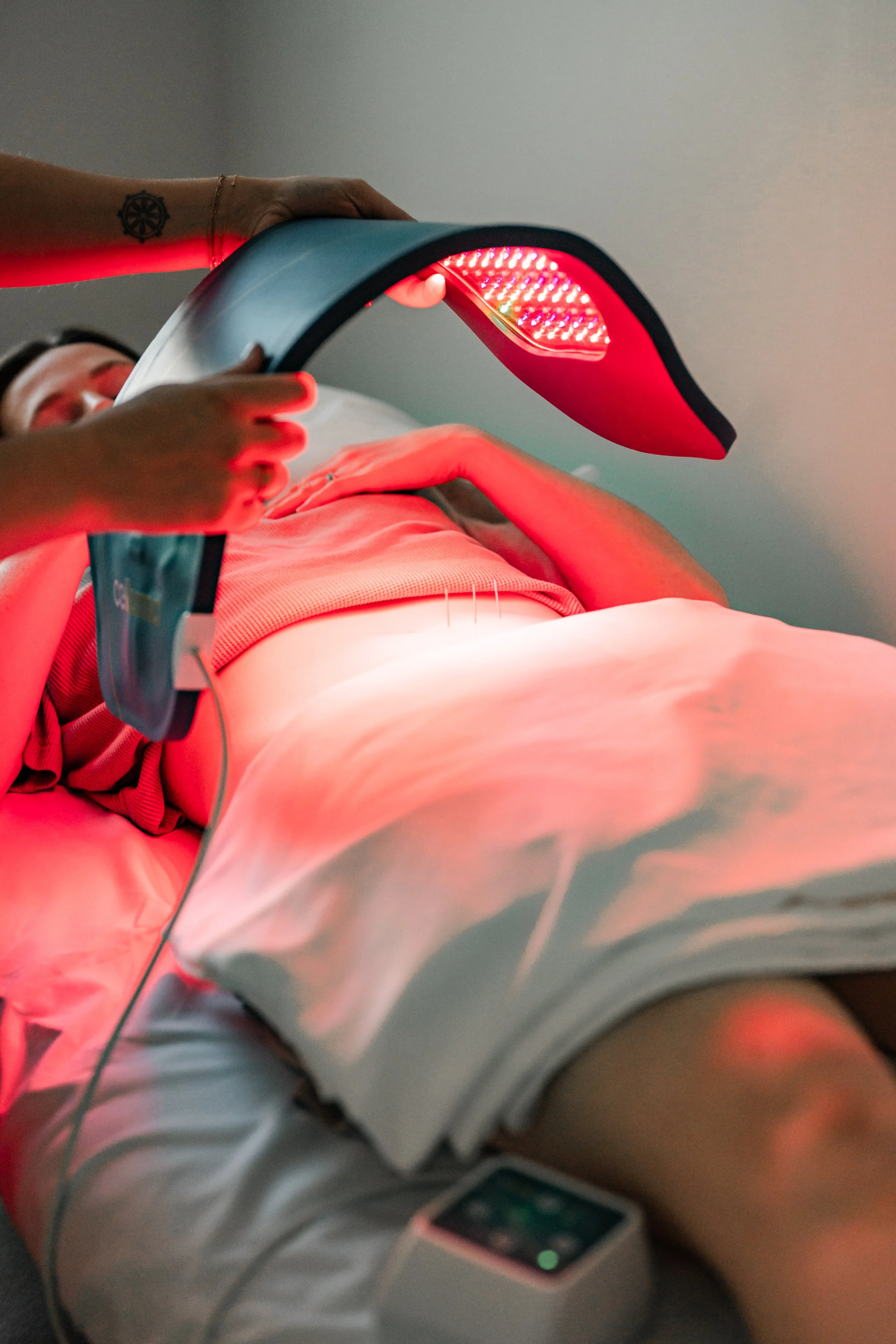 Practitioner using Celluma red light therapy device alongside acupuncture at The Violette House in Groton, MA