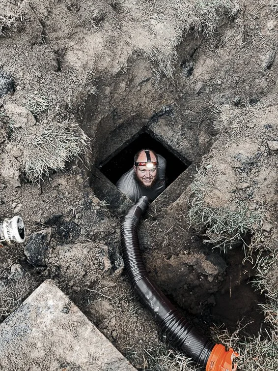 Andrew from ONE Septic Services clearing a tough septic tank blockage in Otisville, Michigan, going above and beyond in septic system maintenance.
