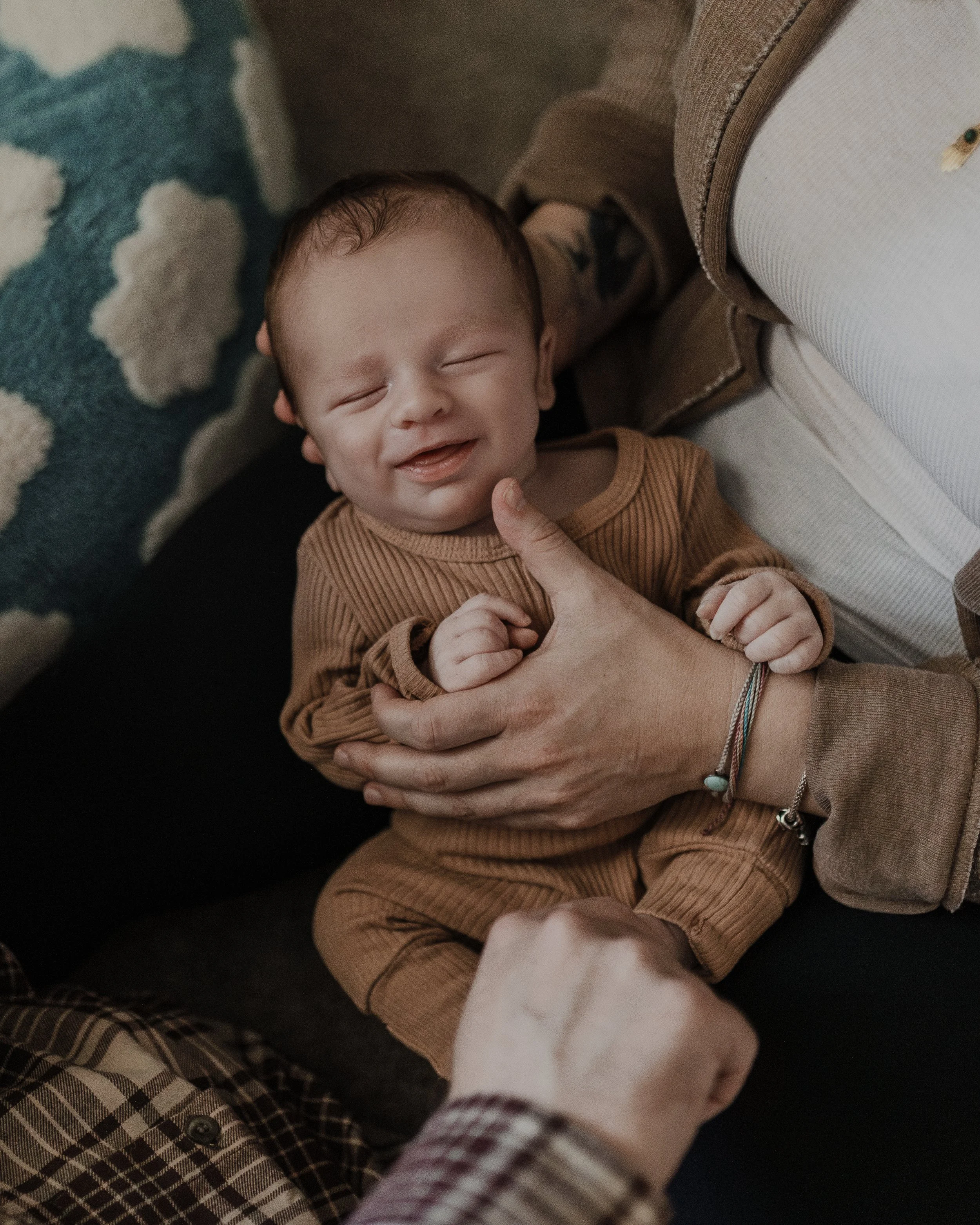 Newborn smiles during a professional photoshoot at home in North Carolina.