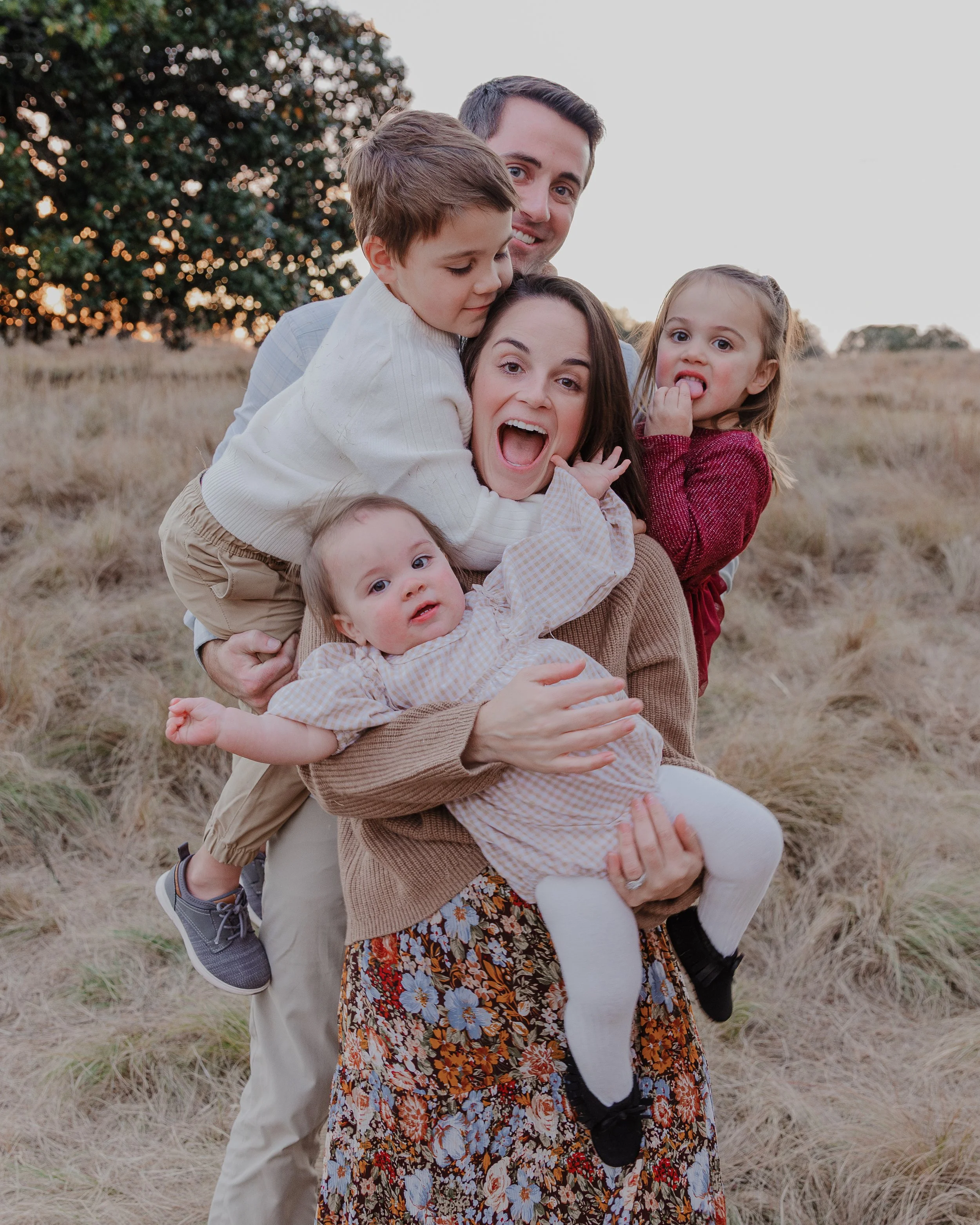 Family with 3 kids makes silly faces while taking fall family photos in Raleigh, NC.