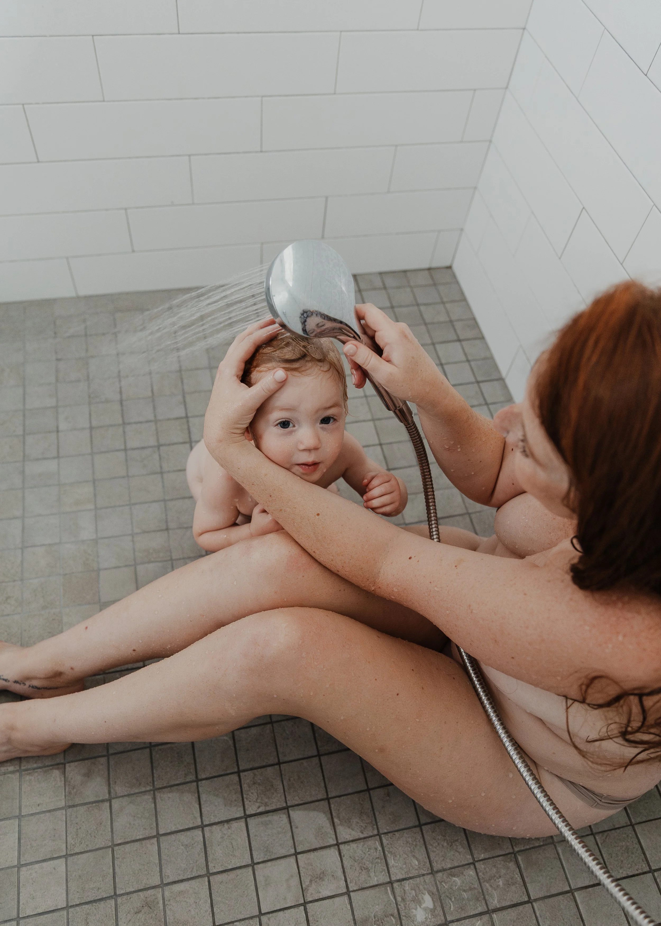 Raleigh mom showers with her toddler during a professional motherhood session captured at home.