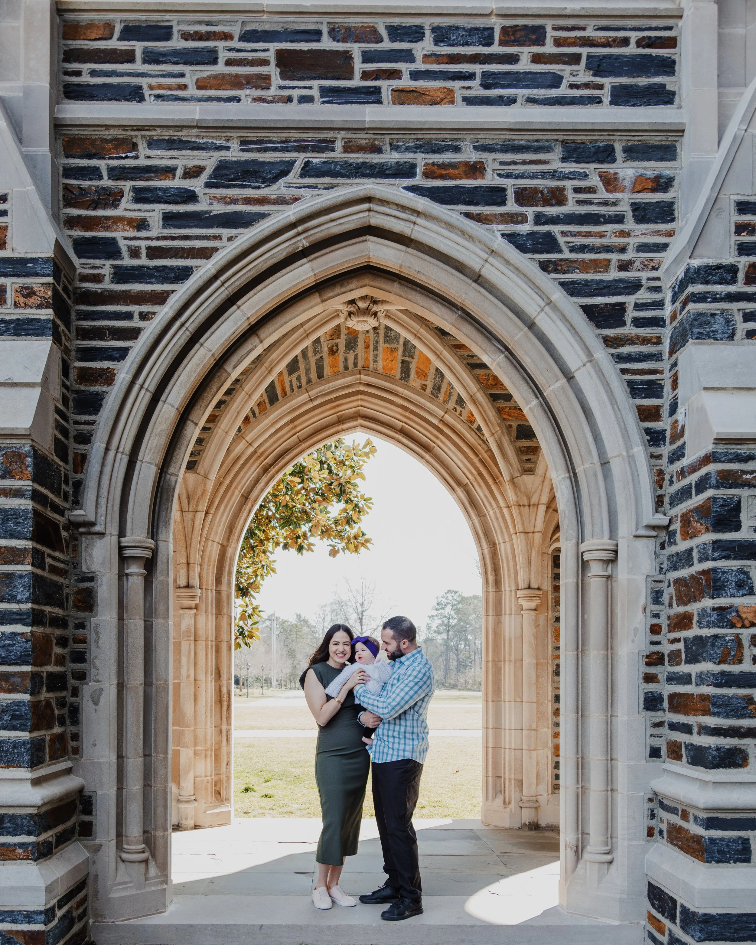 Family stands together under a gothic arch at the Duke University Chapel.