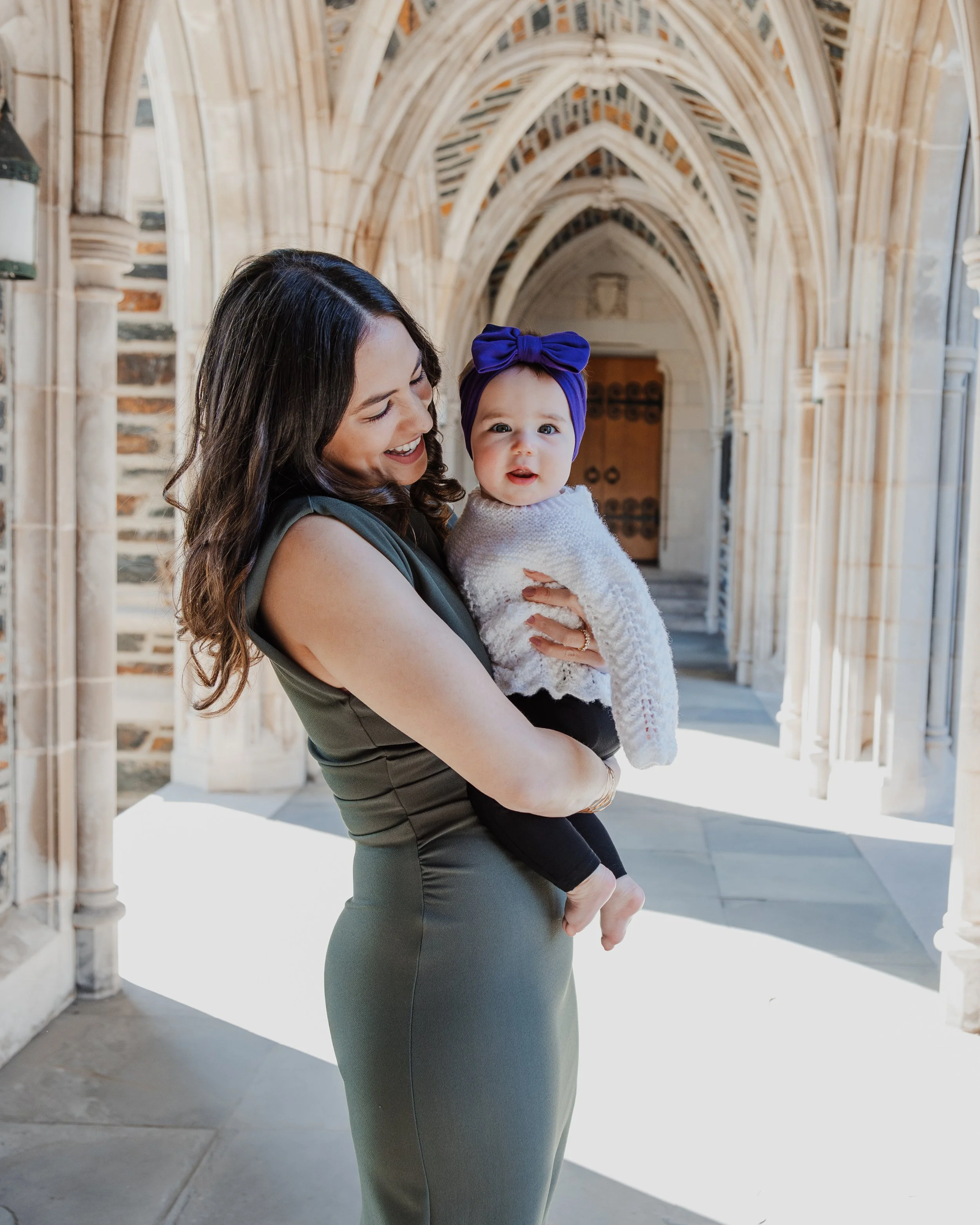 Mom holds baby under gothic arches at Duke University Chapel in Durham.