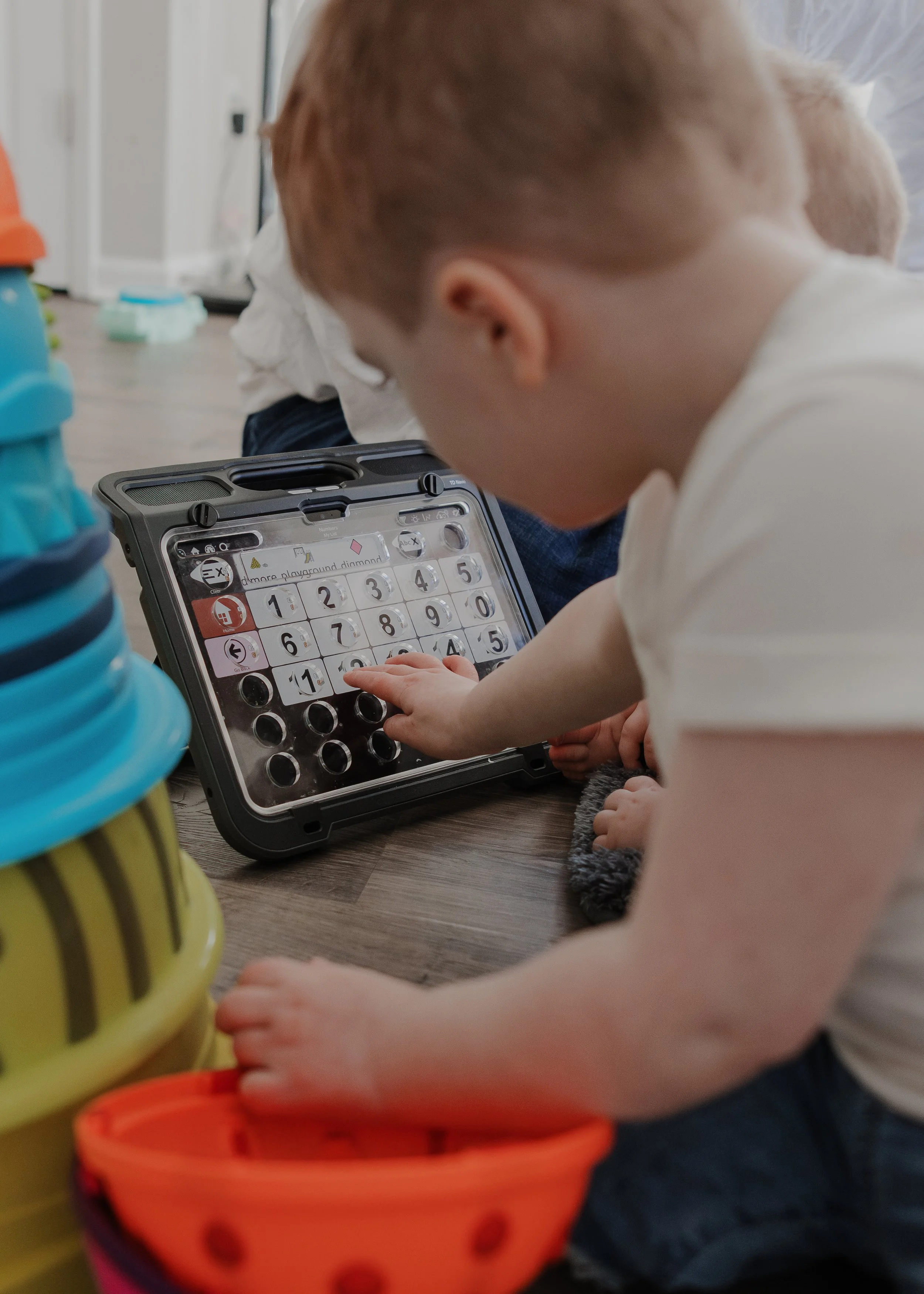 Young boy interacts with an assistive communication device during an inclusive family photography session in Durham, NC.