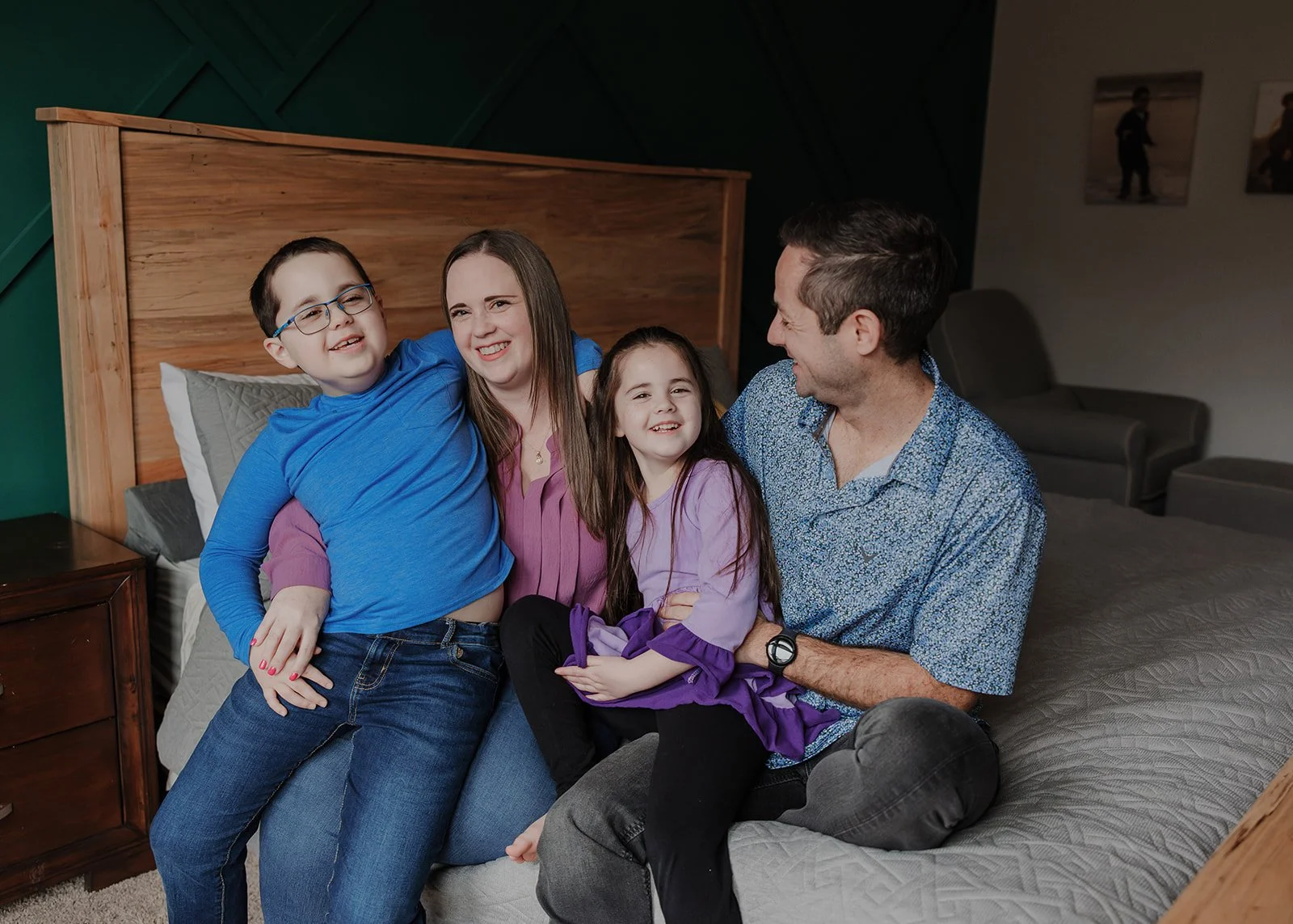 Wake Forest family cuddling together on a bed during a relaxed in-home session designed for a neurodivergent child with Autism, ADHD, and Sensory Processing Disorder.